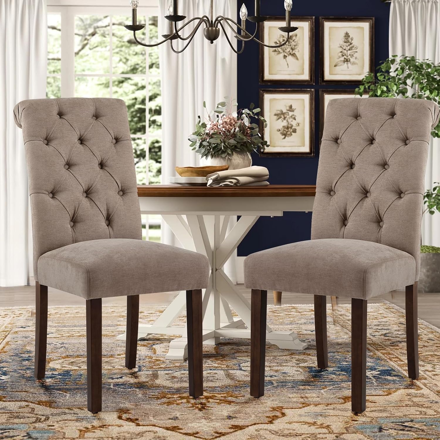 Pair of taupe button-tufted Parsons dining chairs with dark wood legs angled front view by a round dining table