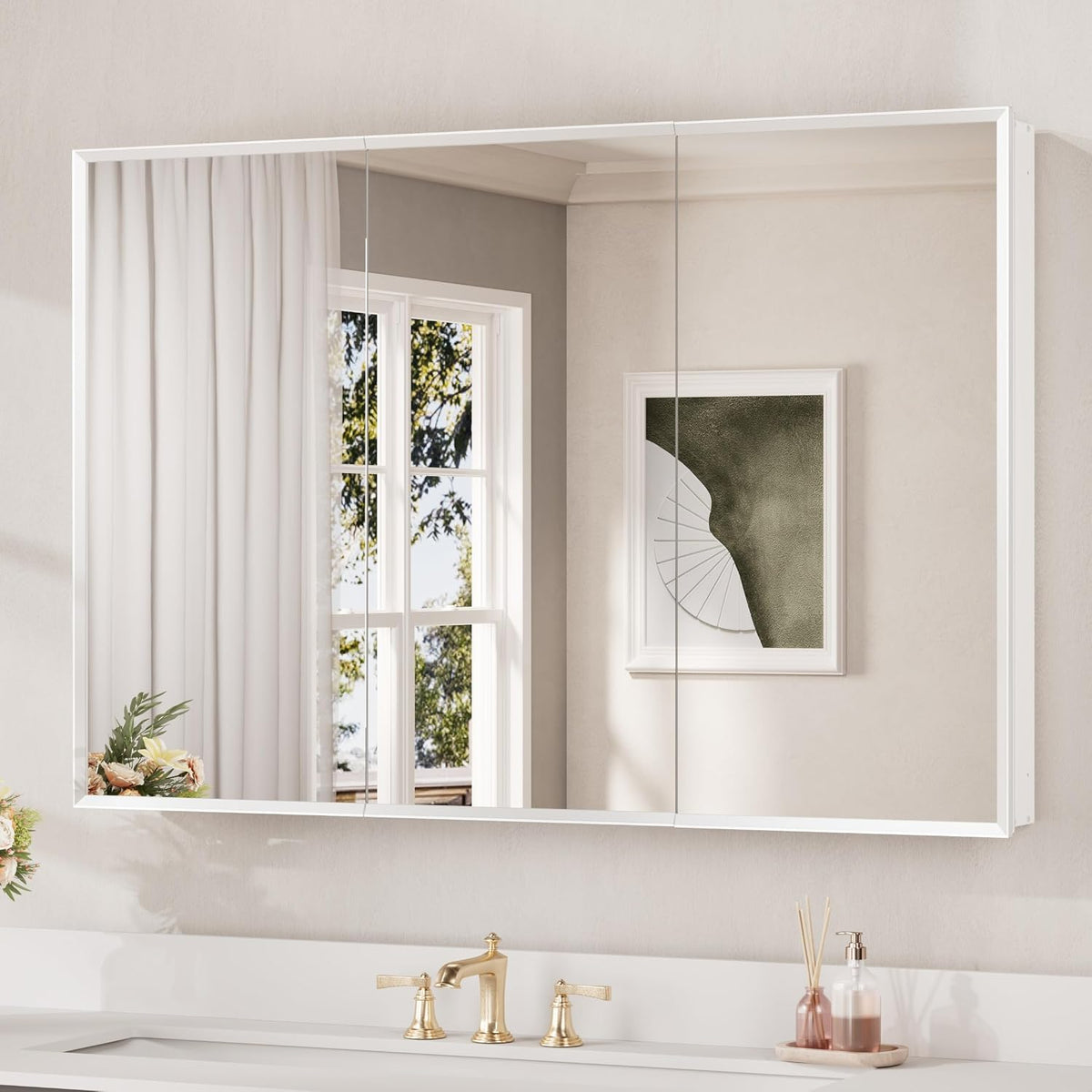 Wide white-framed mirrored medicine cabinet with two mirrored doors above a white countertop and gold faucet