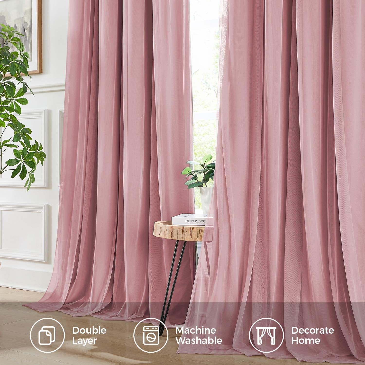Floor-length sheer pink curtains layered over solid panels next to a small round wood side table and plant.