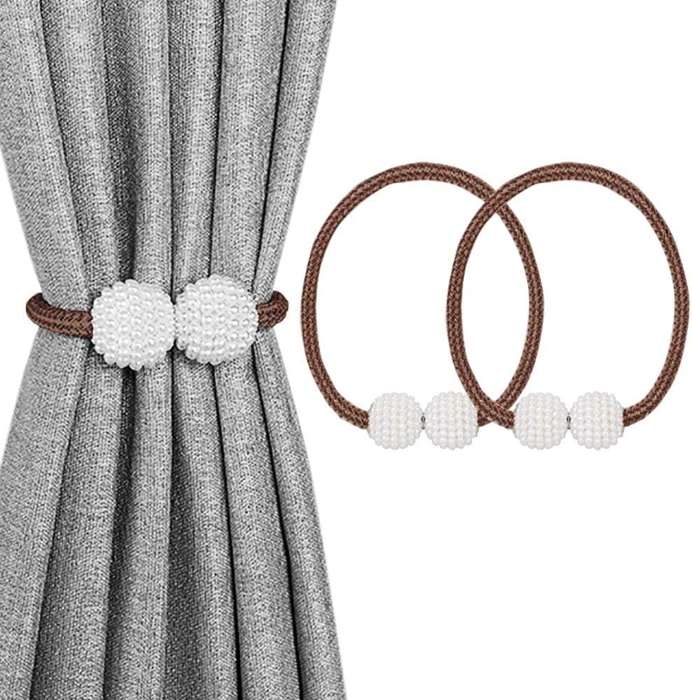 Gray curtain held by a brown rope tieback with two white beaded magnetic balls; two brown tieback loops at right.