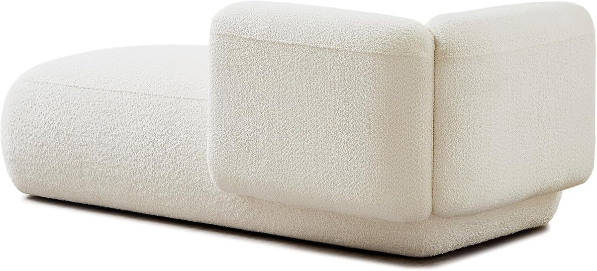 Rear and side angle of the chaise showing the arm detail, rounded form, and low wooden base