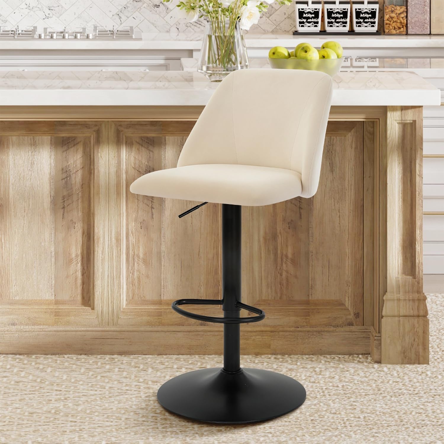 Single beige fabric bar stool at a light wood kitchen island showing curved seat and black footrest