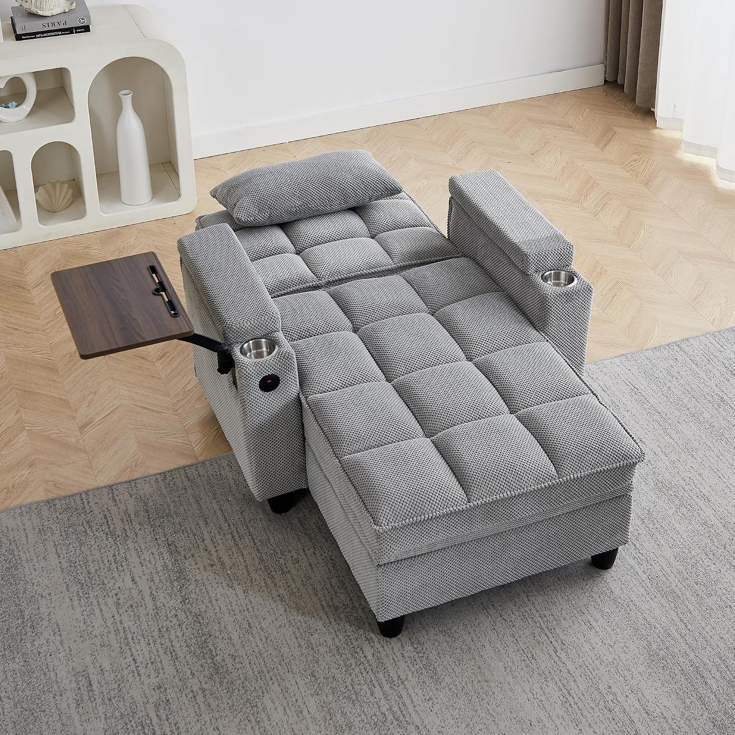 Light gray textured chenille chaise from above-right showing pillow, wooden swivel tray and stainless cup holder on arm