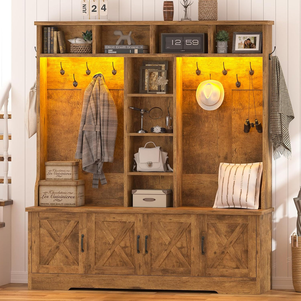 Rustic brown hall tree with warm yellow LED-lit cubbies, hat, coat, decorative boxes and pillow on the bench.