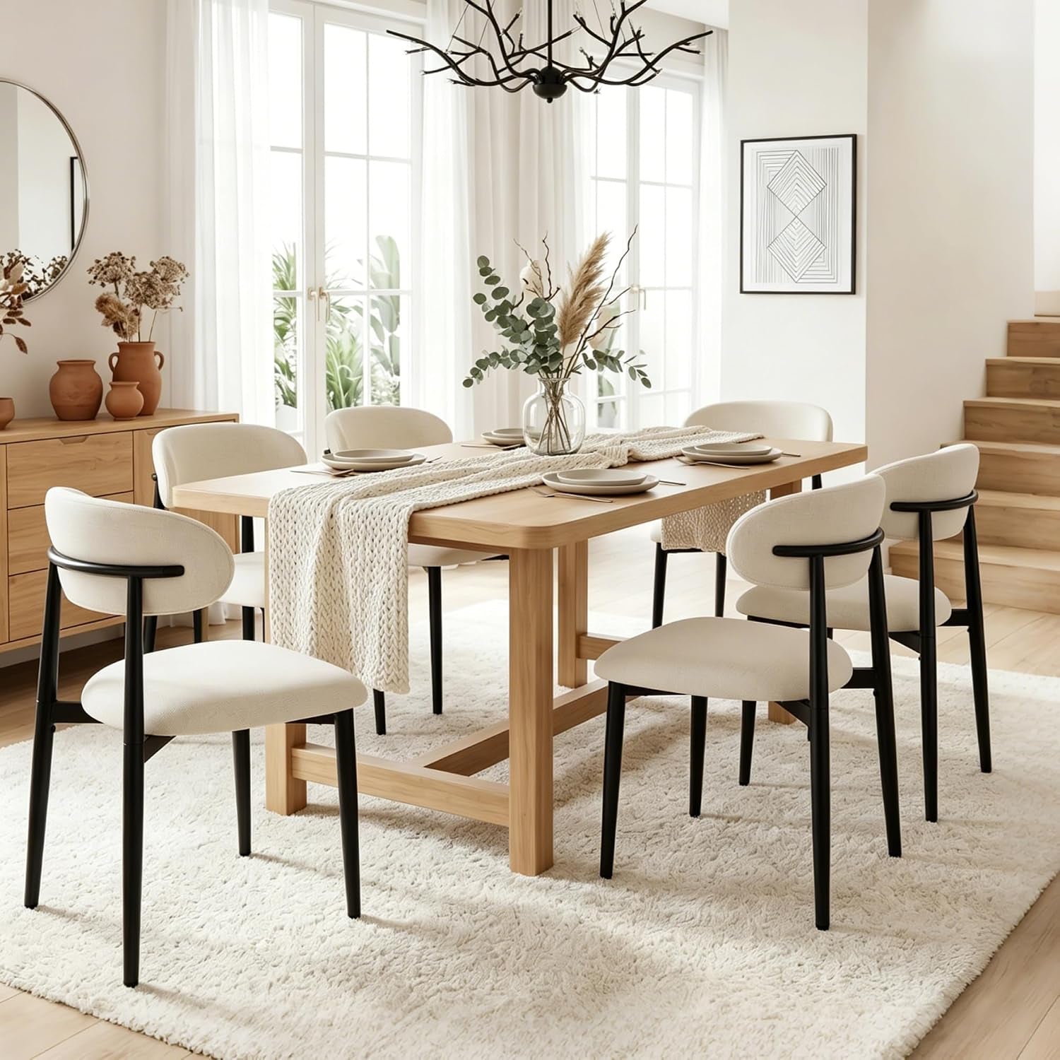 Six beige upholstered chairs with matte black metal legs arranged around a rectangular light-wood dining table on a plush rug