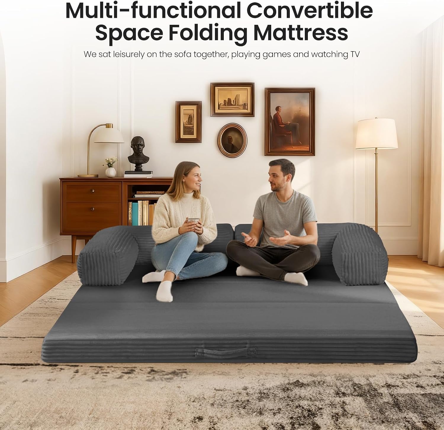Grey mattress laid flat on floor being used as a large floor sofa with two people sitting on it