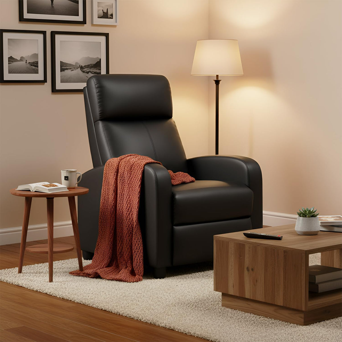 Black PU leather recliner staged in a living room with a rust-colored throw on the armrest