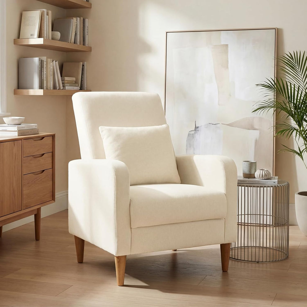 Beige upholstered accent chair with pillow angled front view in a living room setting
