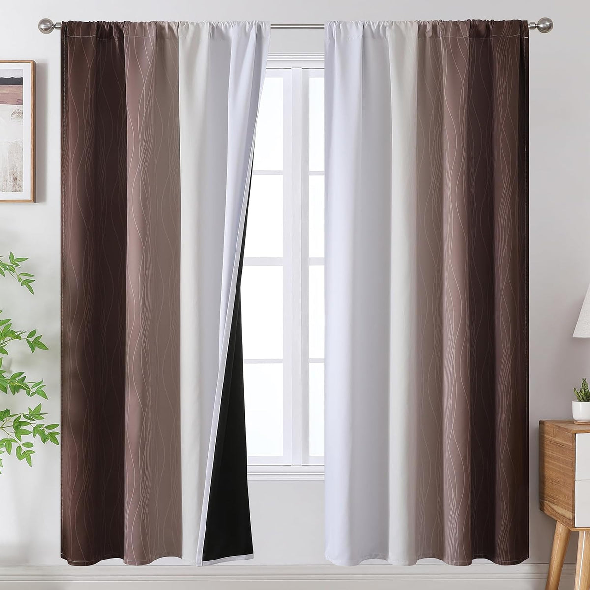 Pair of rod-pocket curtains with brown-to-white ombre and wavy line pattern, left panel parted to reveal black backing and