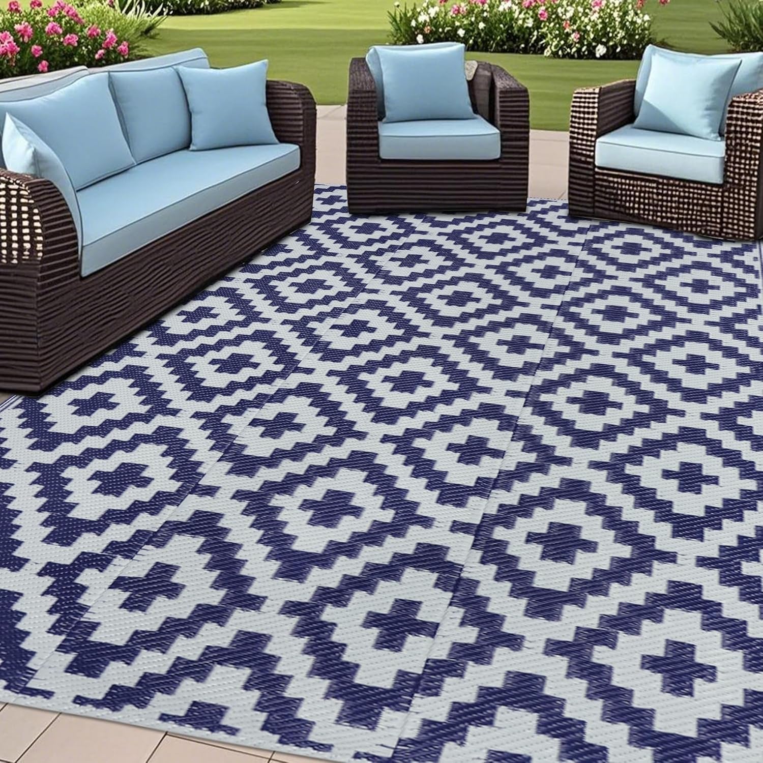 Outdoor patio setup with woven sofas on a navy-and-white geometric outdoor rug.