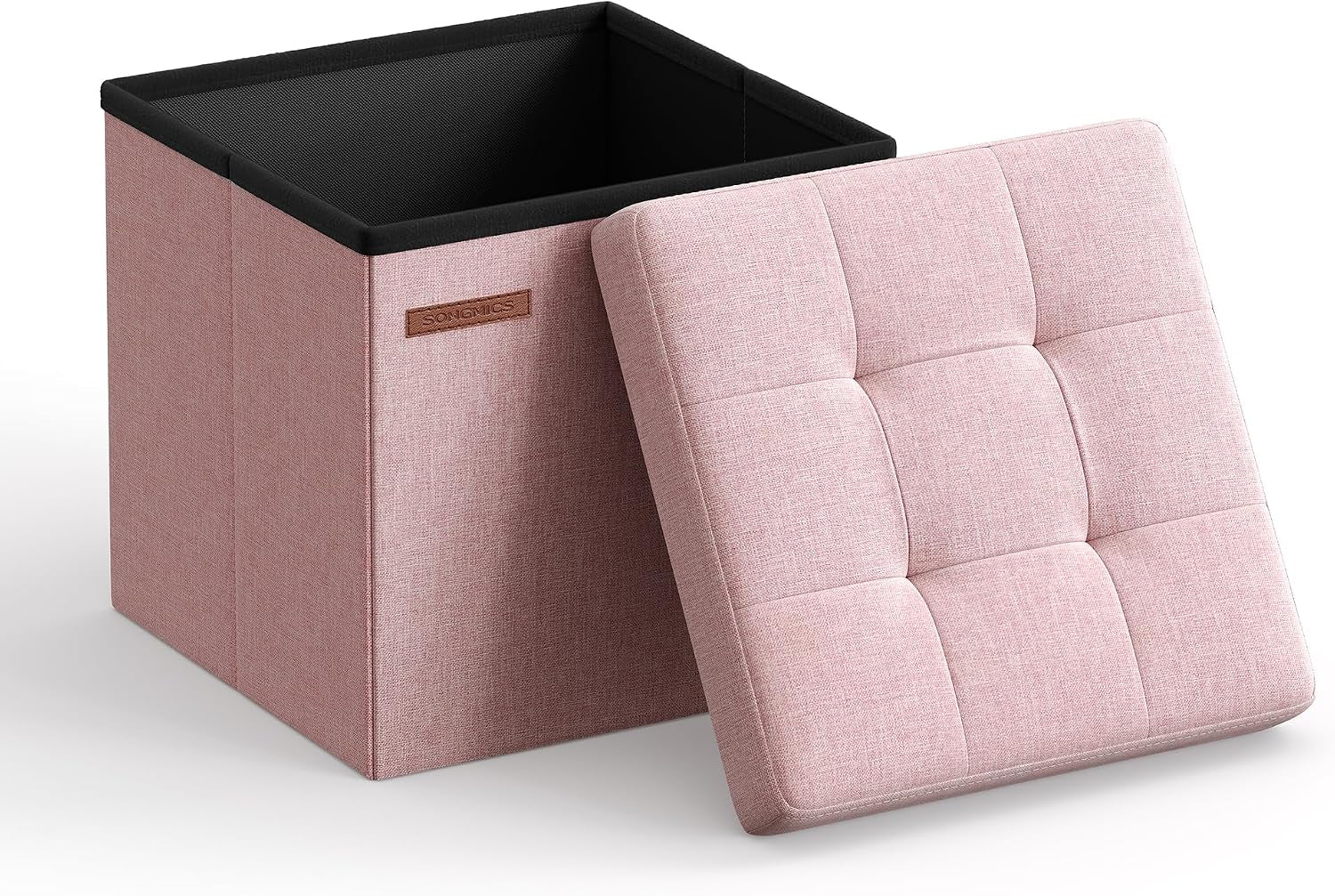Open blush pink fabric storage cube with tufted lid propped against it