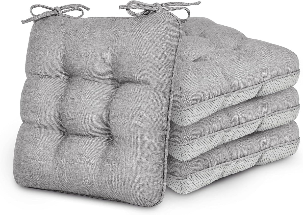 Stack of four tufted square chair cushions in light gray with corner tie strings