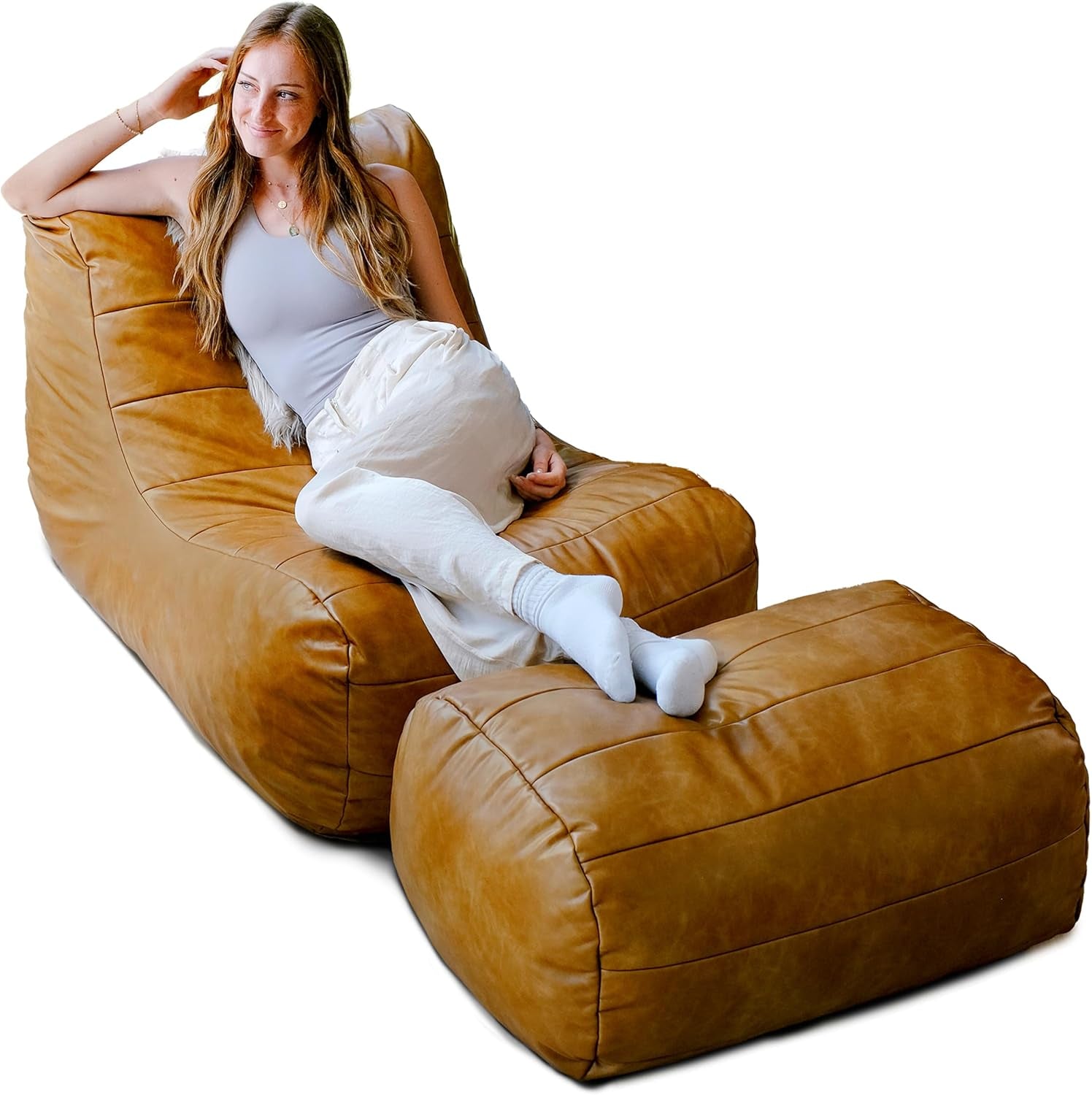 Caramel tan lounge chair with matching ottoman, front-left angle showing person reclining