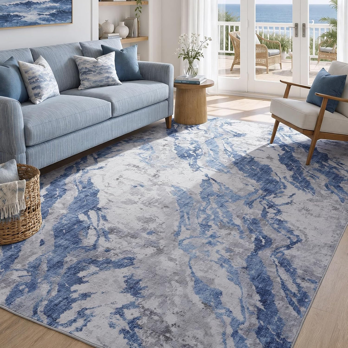 Lighter blue and gray marbled rug visible under a sofa and armchair with a sunlit balcony beyond.