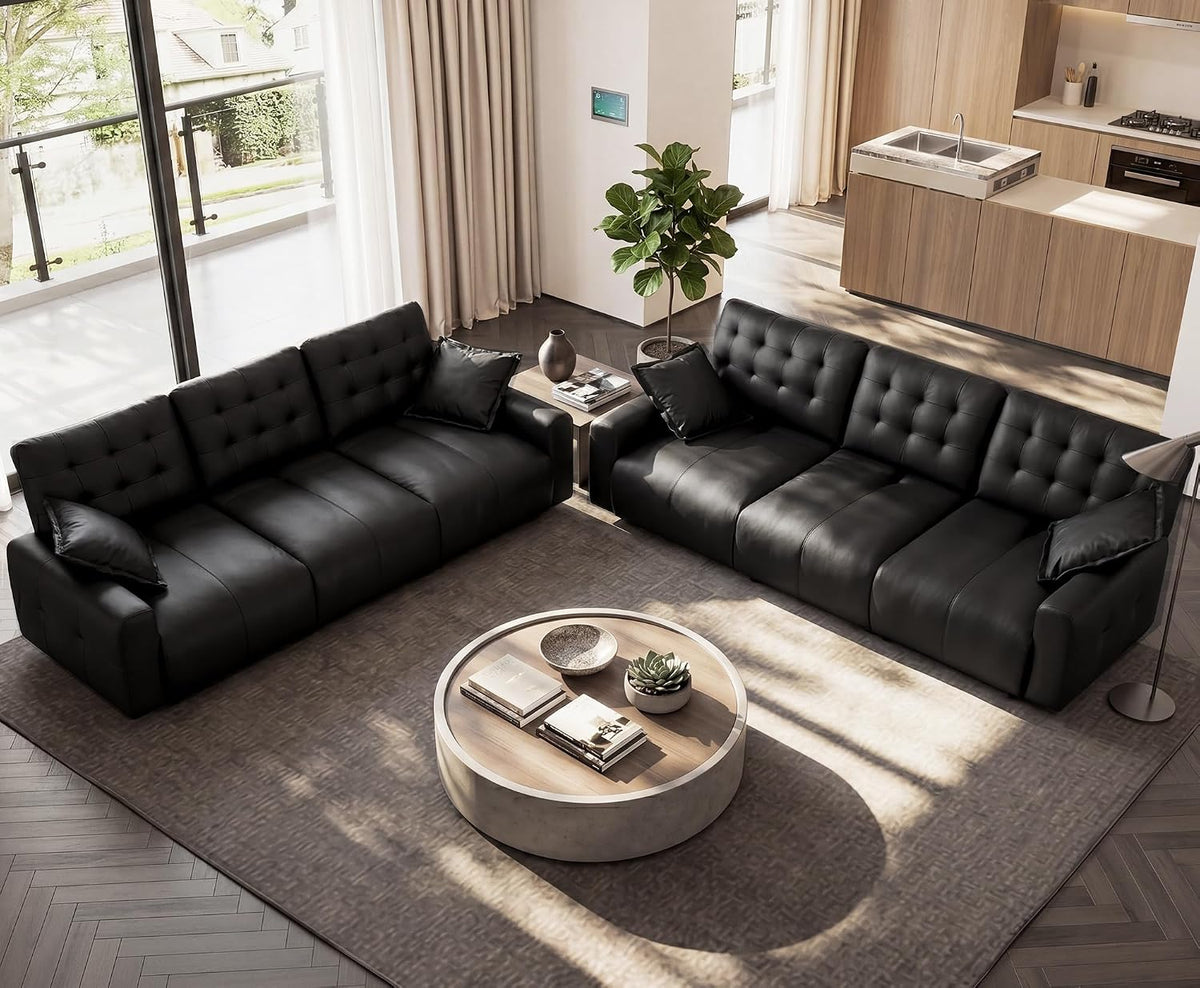 Top-down view of two matching tufted leather sofas facing each other in a bright open-plan living area.