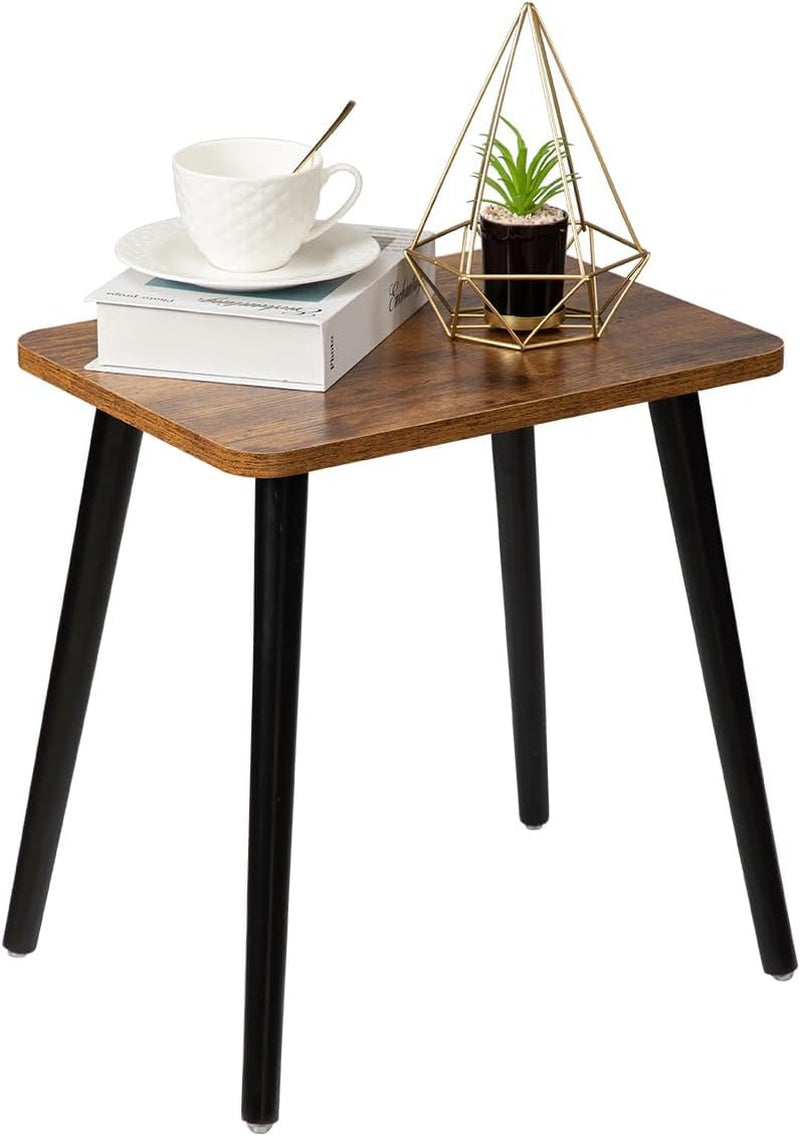 Small rectangular side table with dark wood top and four tapered black legs, styled with cup and planter.