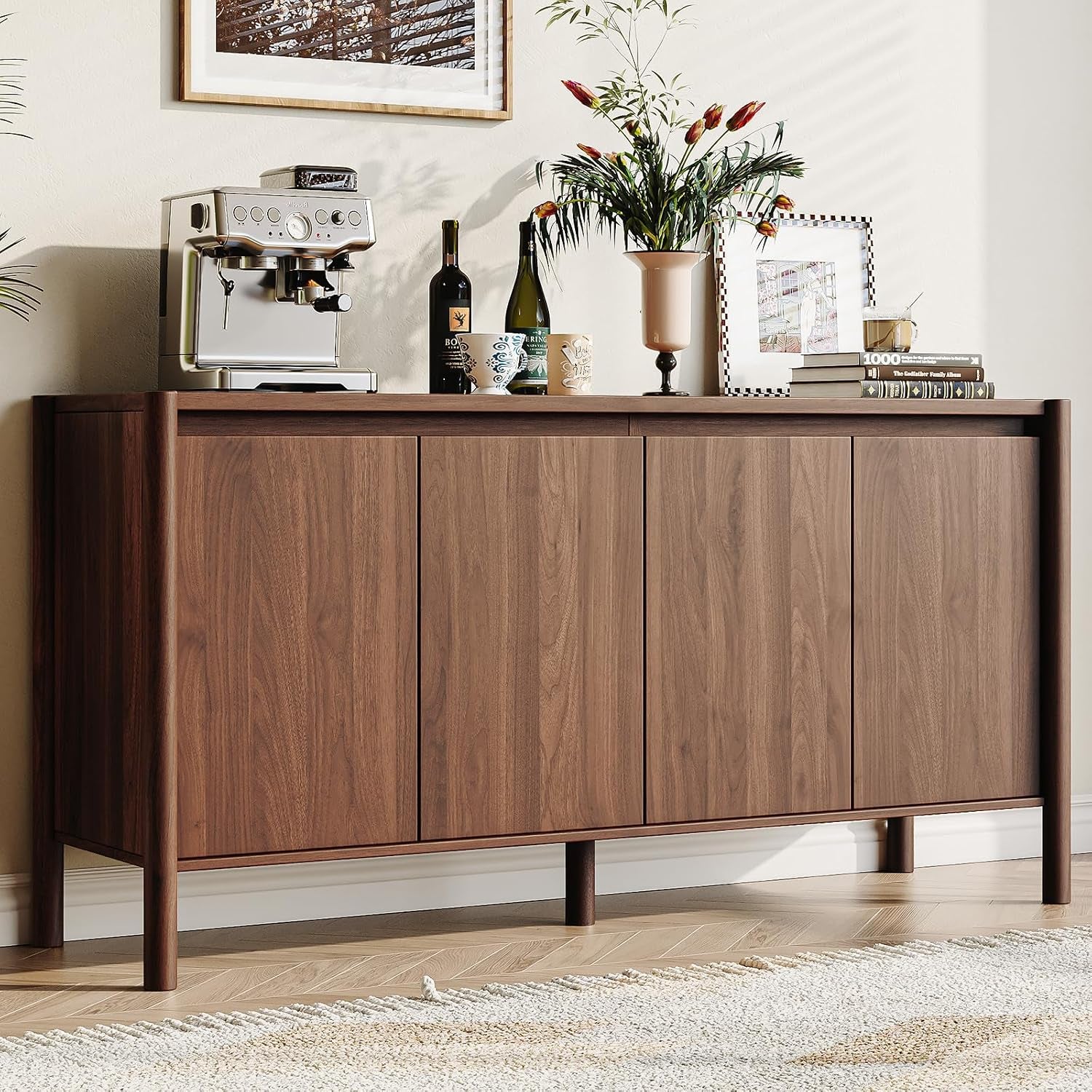 Walnut sideboard topped with a coffee machine, bottles and decor in a styled dining area