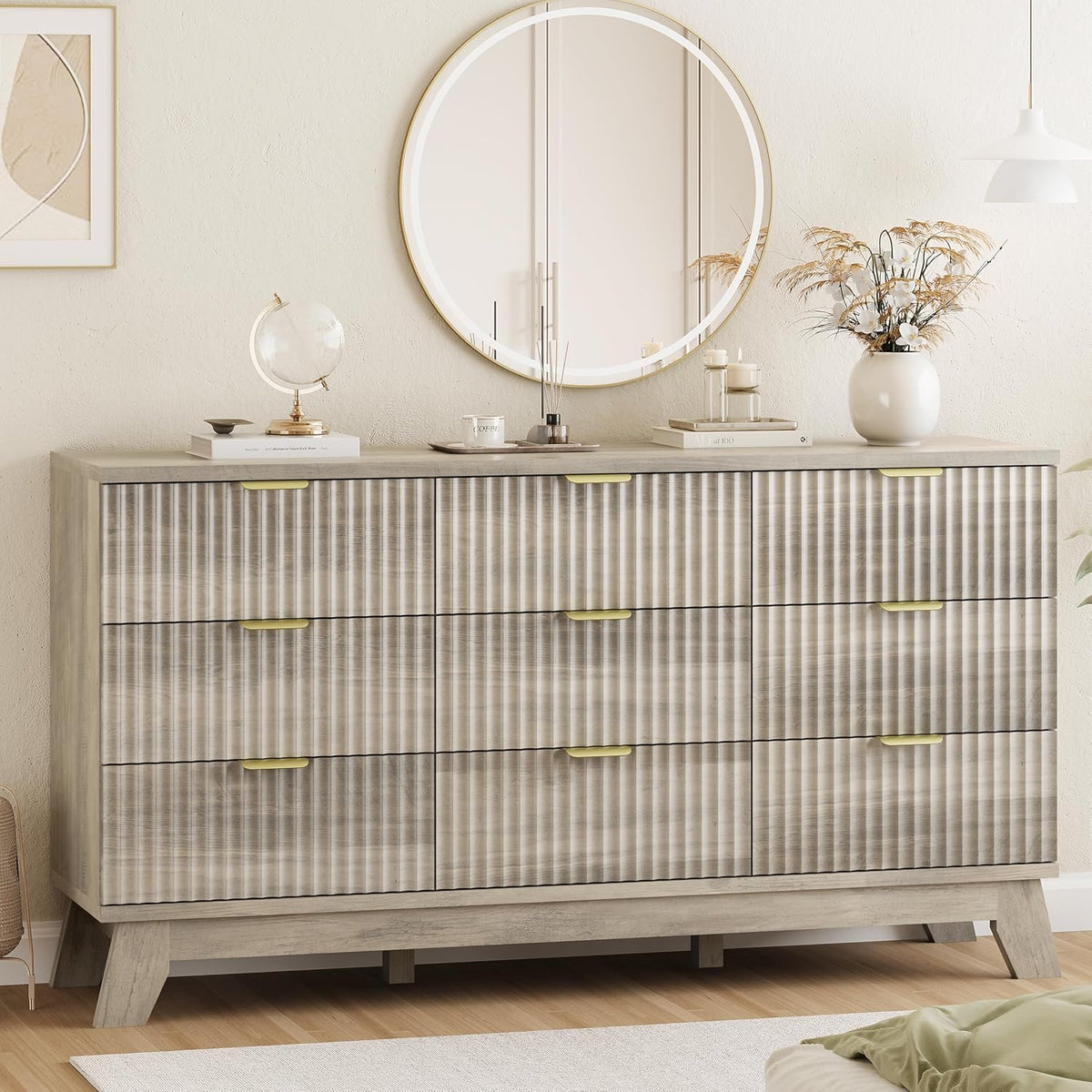 Close front view of a graywashed wave-panel dresser top decorated with globe, tray, and vase under a round mirror.