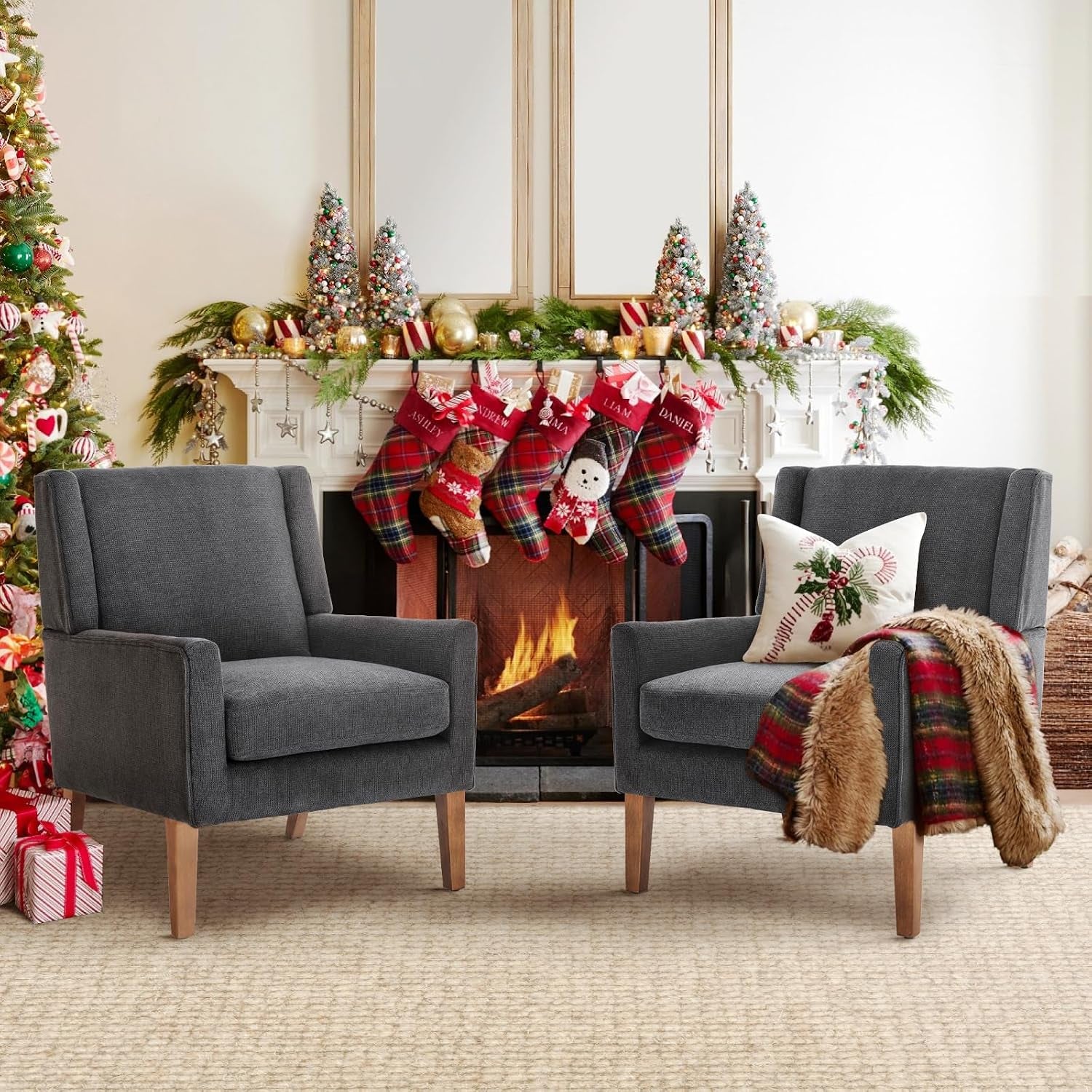 Pair of dark gray chenille wingback chairs arranged in front of a festive mantel and lit fireplace