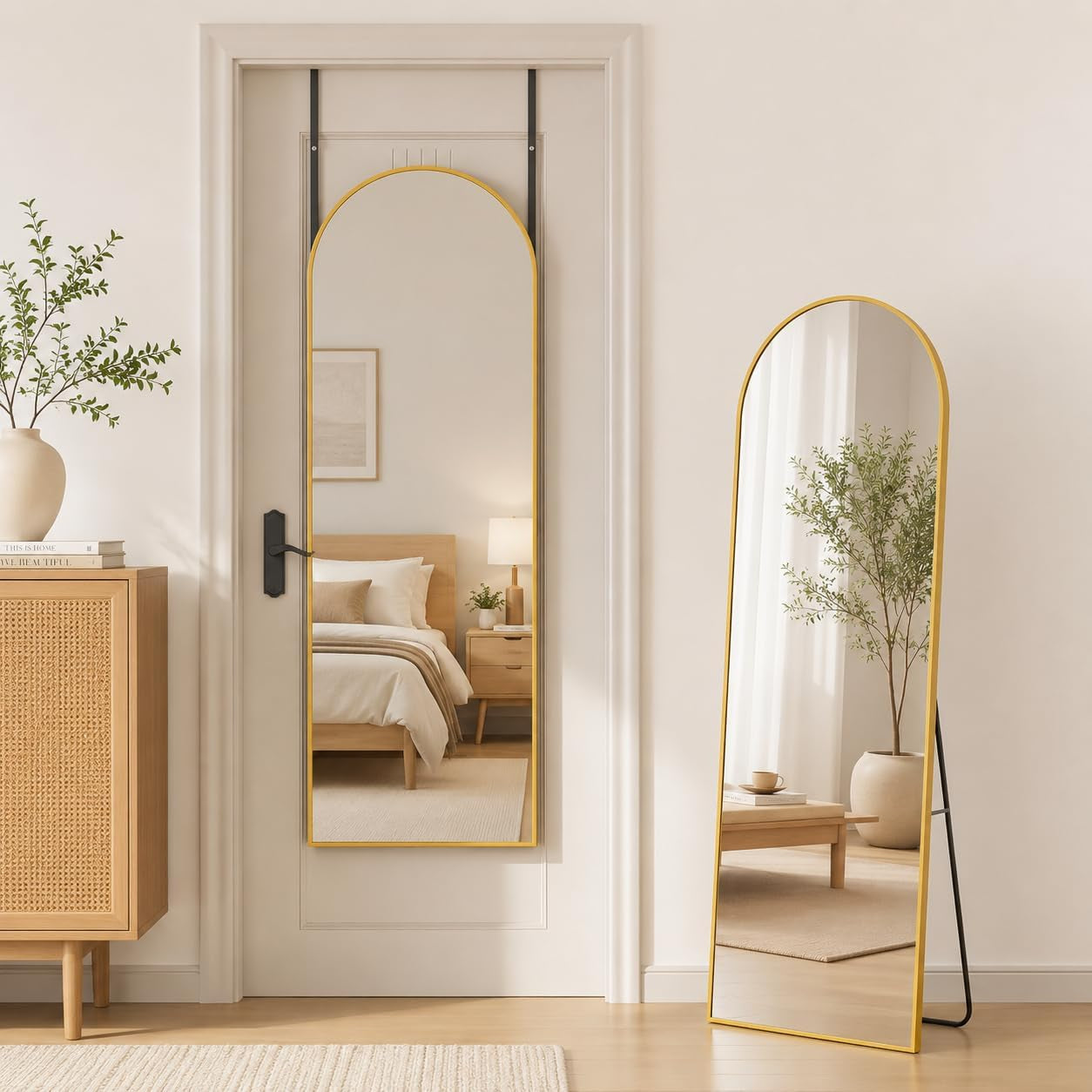 Two arched mirrors: a gold-framed mirror hung on a door and a matching freestanding mirror leaning nearby.