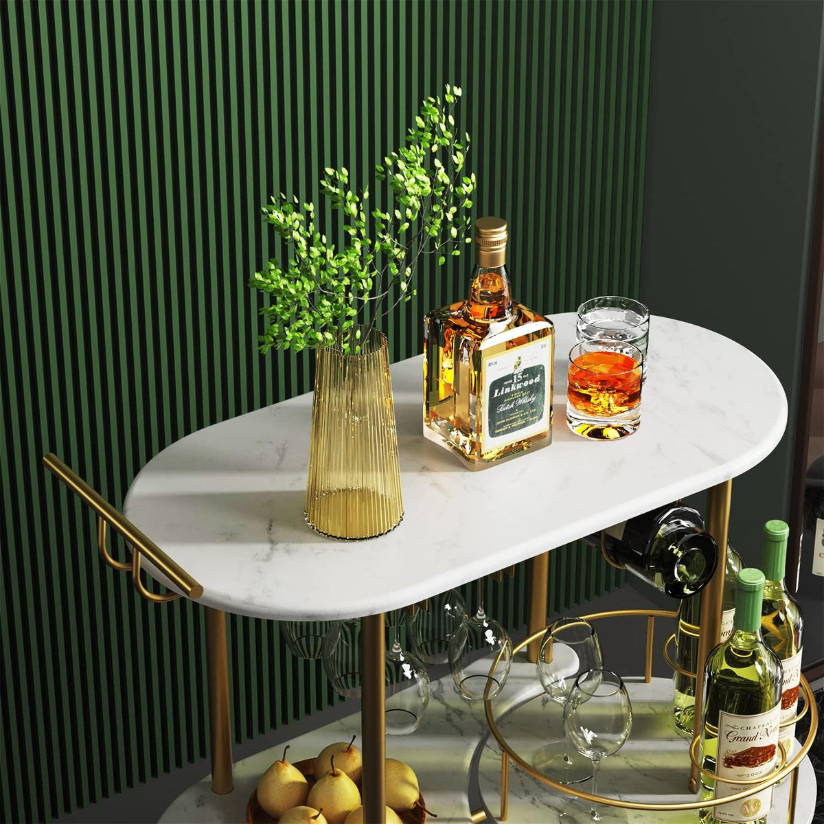 Top-front view of a gold-framed bar cart with white marble shelves holding bottles, glasses and a vase.