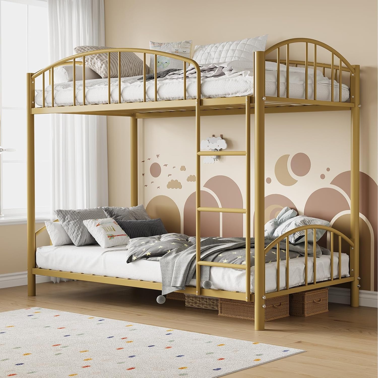 Gold metal twin-over-full bunk bed with ladder, pillows on both beds and storage baskets underneath.