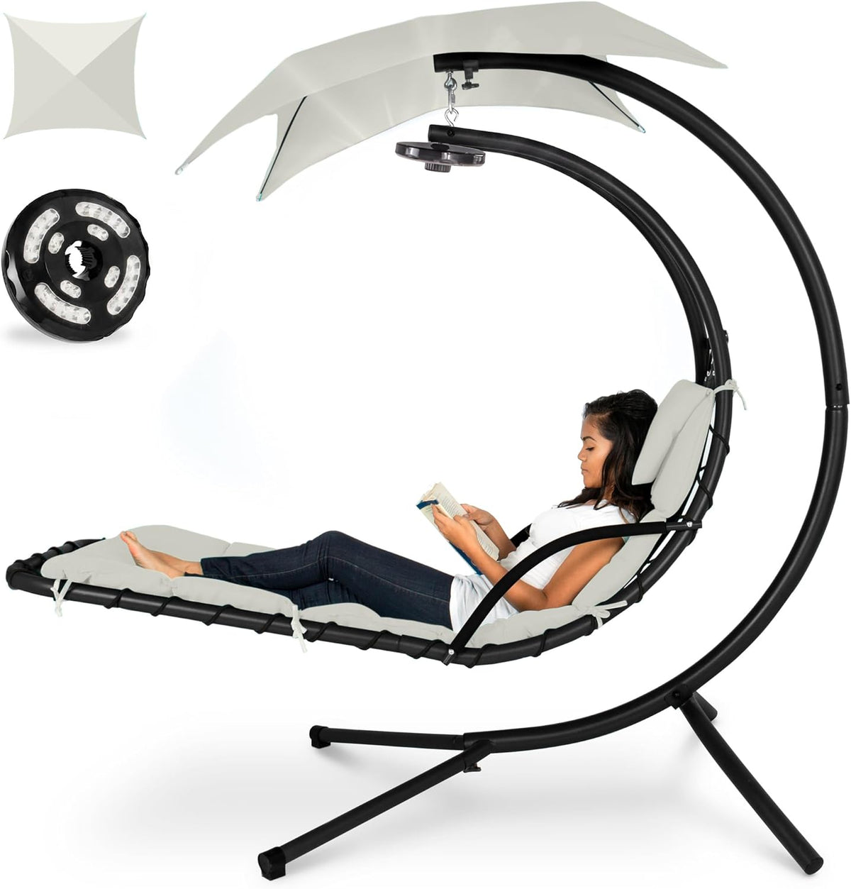 Curved hanging chaise shown with light gray cushions and canopy, woman reclining and reading