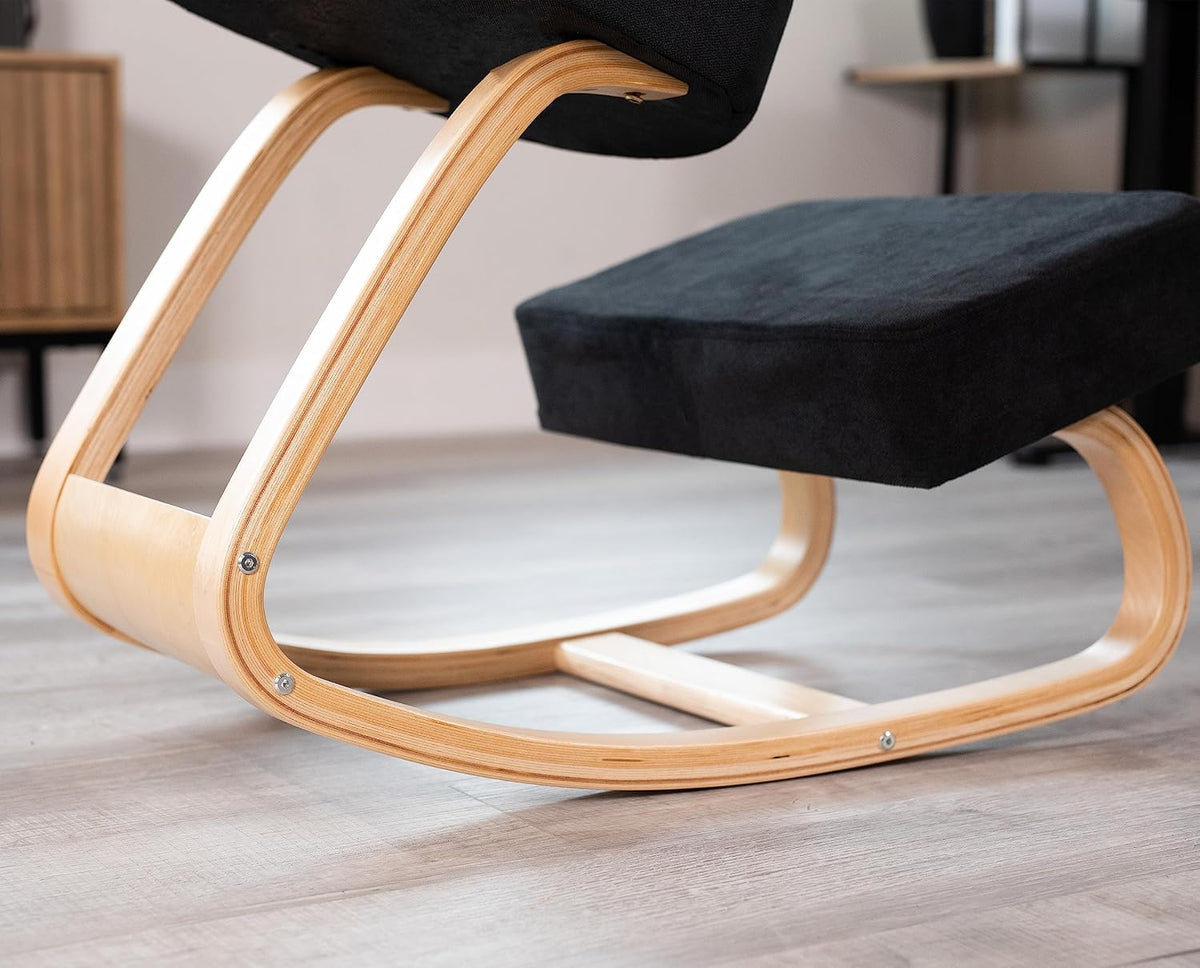Close-up side detail of light beach wood rocker frame and black mesh knee cushion on a wood floor