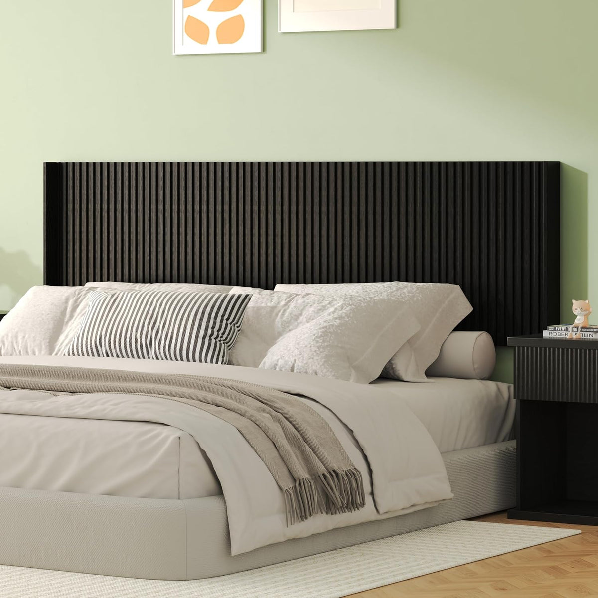 Low-angle bedroom view showing a black fluted wall-mounted headboard against a pale green wall.