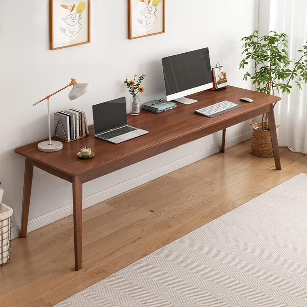 Angled view of the walnut desk with a desktop monitor, laptop, keyboard and small desk accessories arranged across the top.