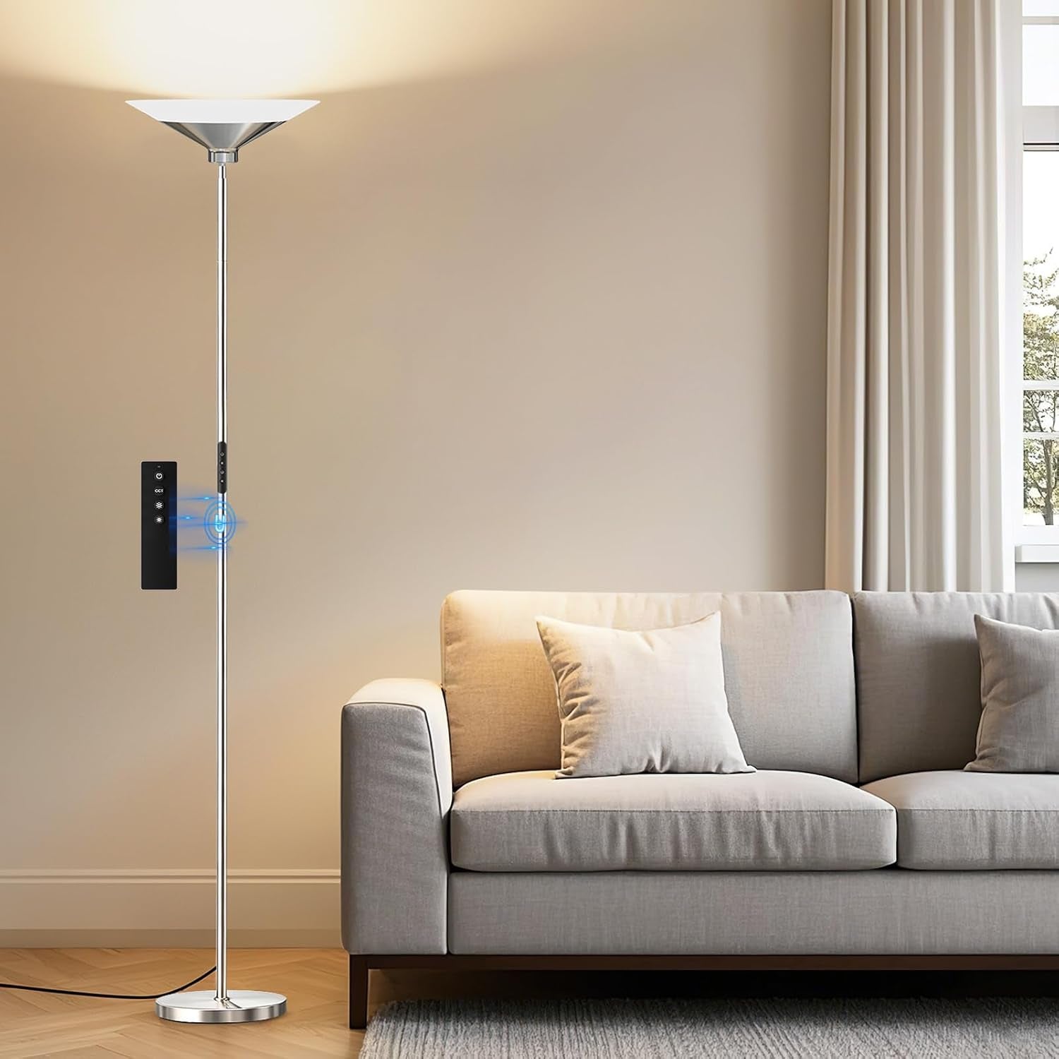 Brushed nickel torchiere lamp beside a pale sofa, shown in a bright daytime room setting.