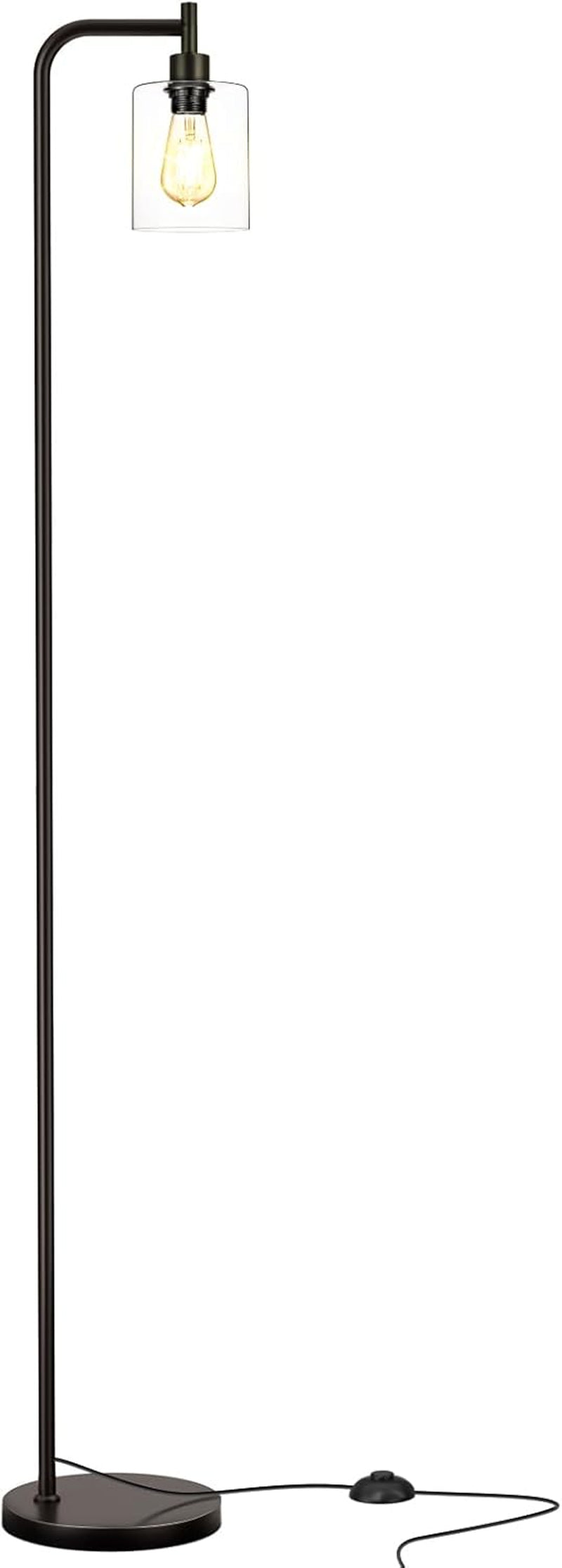 Full-length black standing lamp with curved arm, clear glass cylindrical shade, round base and visible foot-pedal cord.
