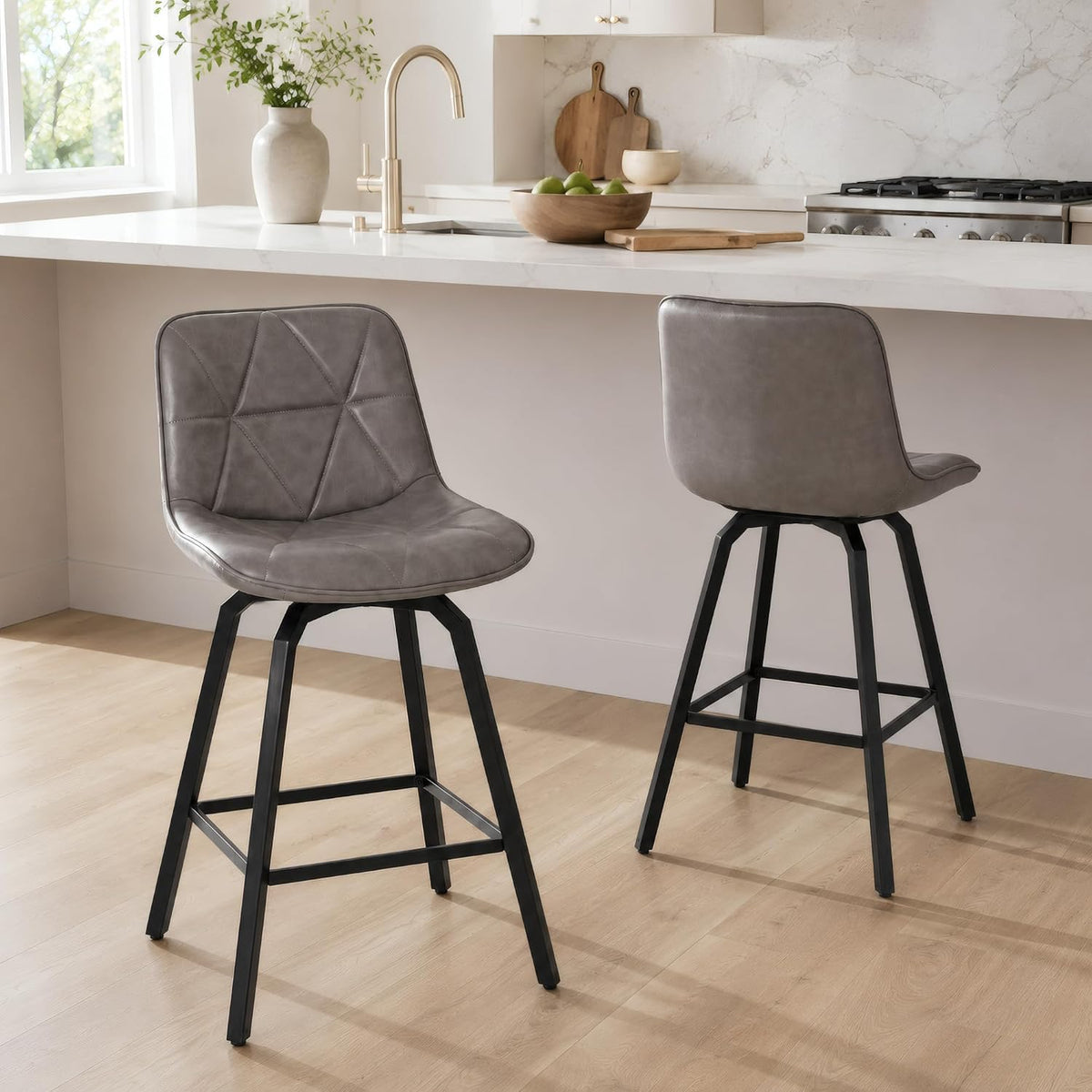 Two gray faux-leather counter stools with triangular stitching and black metal bases