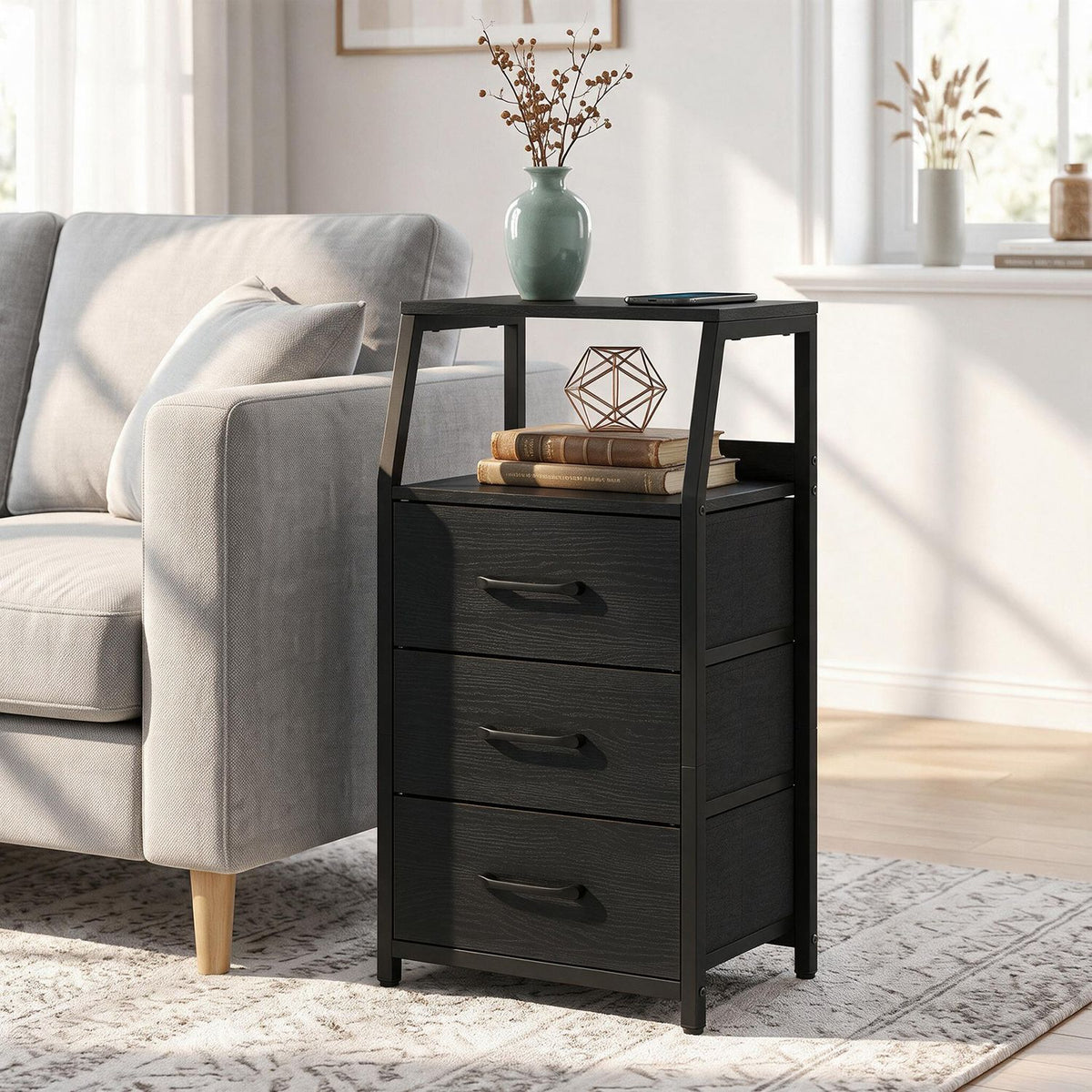Black three-drawer nightstand beside a sofa, shown with its open shelf and tabletop.