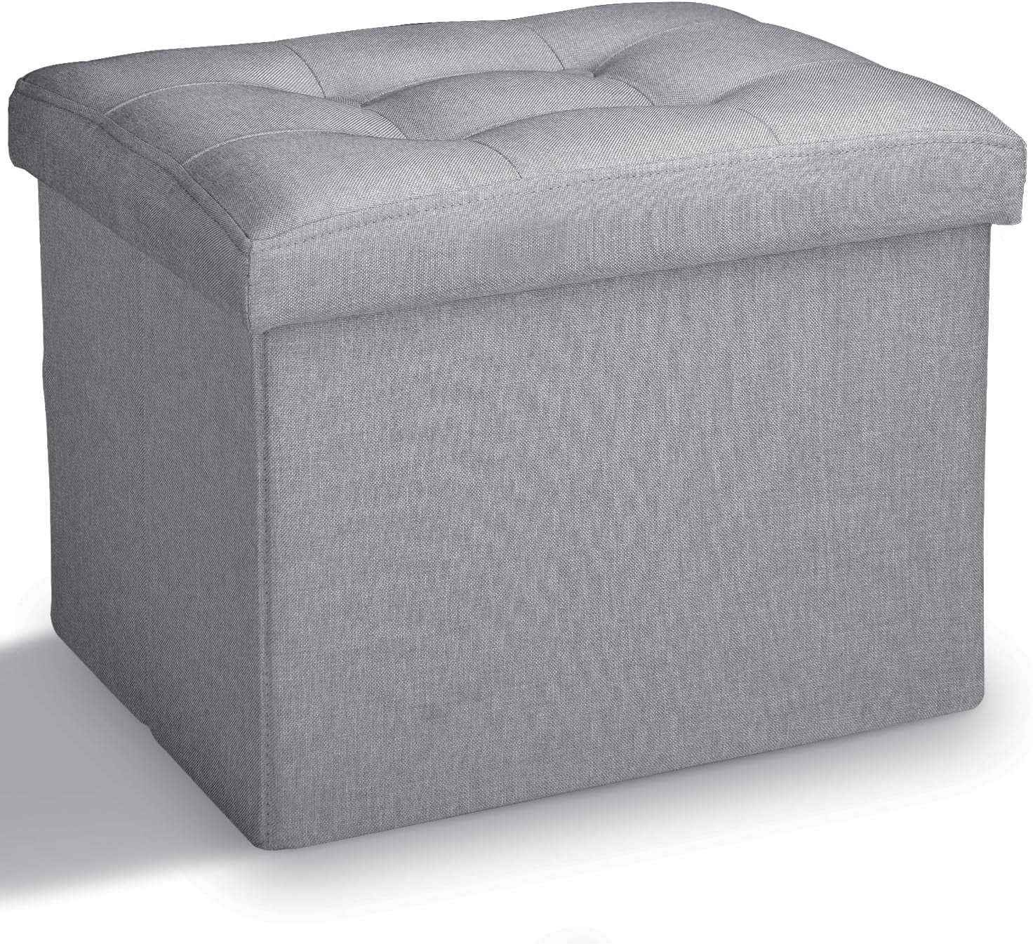 Three-quarter view of a square dark gray fabric storage ottoman with tufted cushioned top.