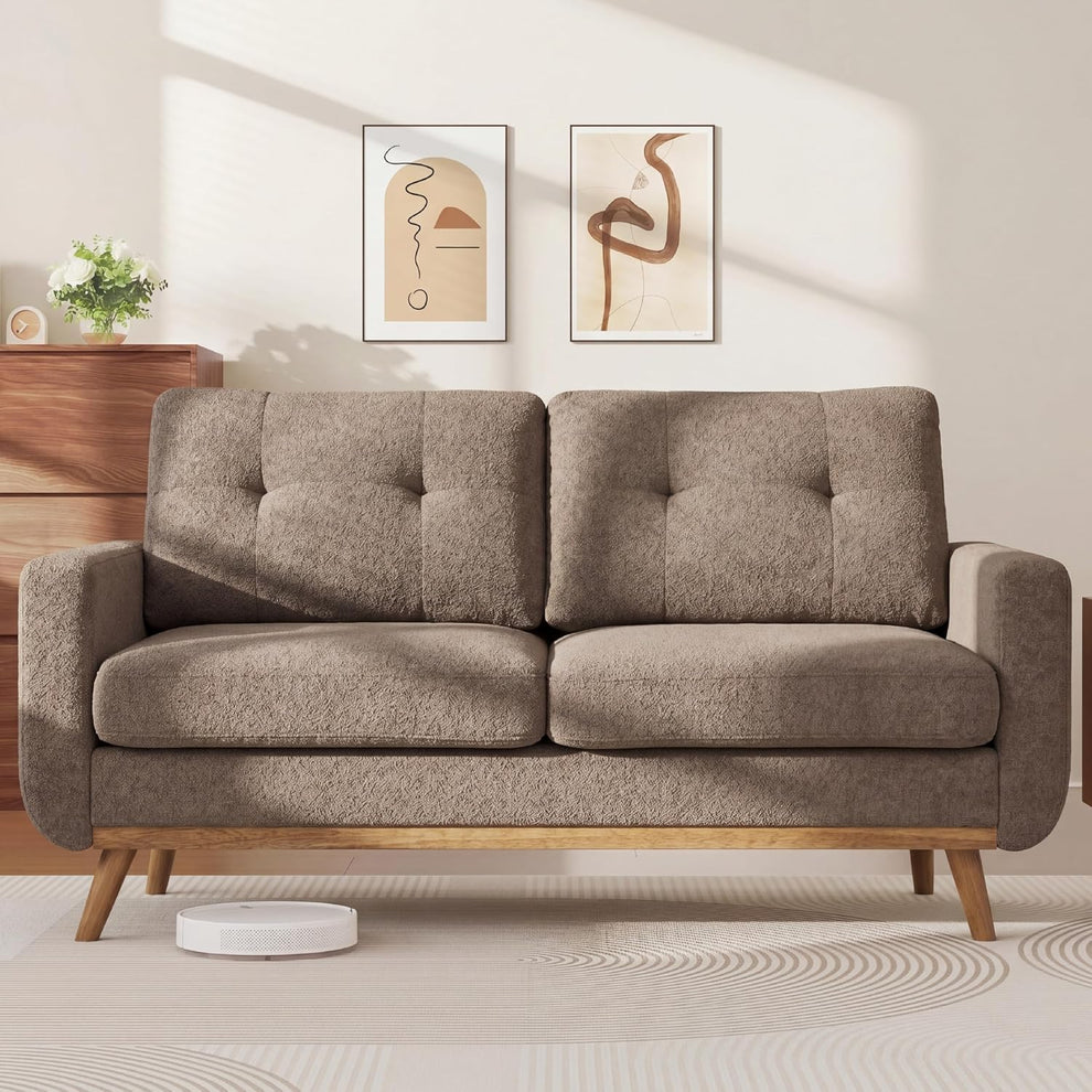 Camel tufted loveseat futon front view with wooden base and angled legs in a living room setting