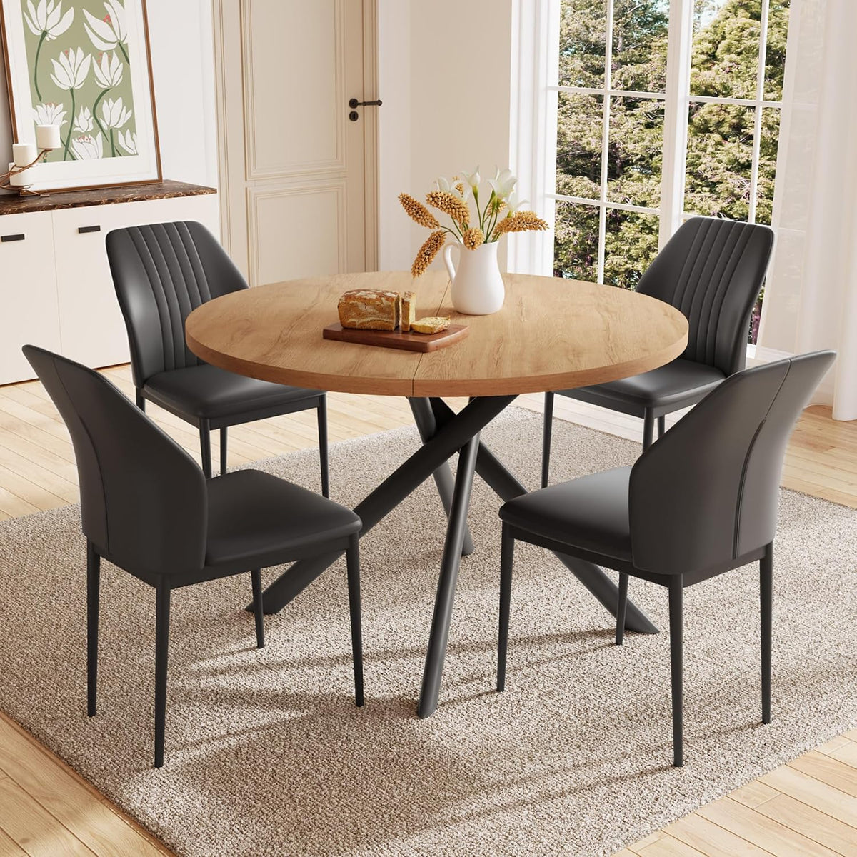 Round walnut table with four dark gray/black upholstered chairs and crossed metal legs