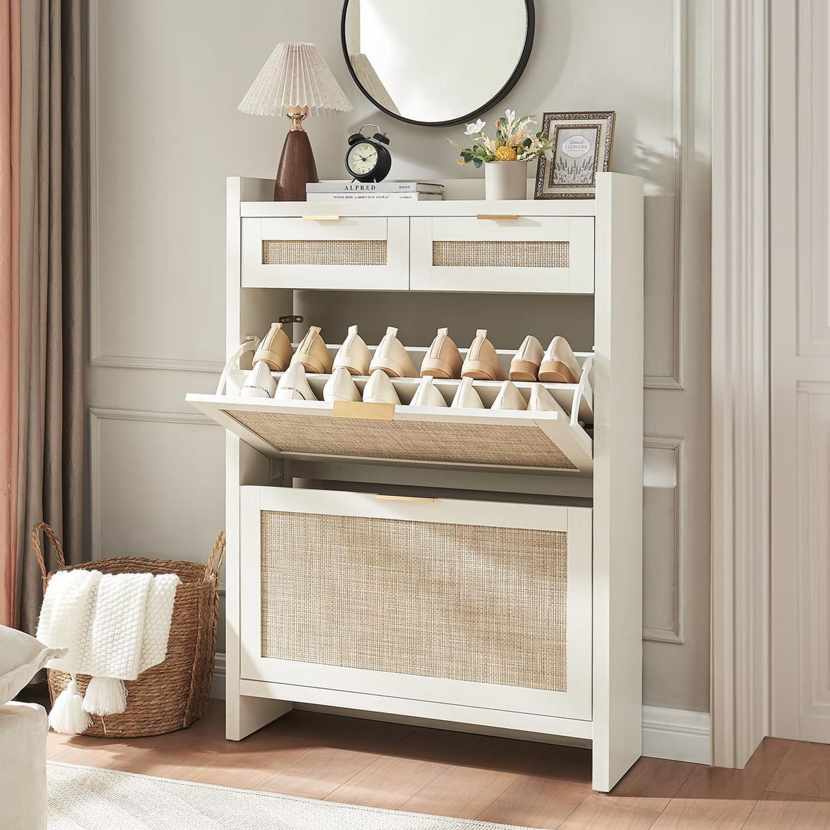 White rattan-front shoe cabinet staged under a round mirror with lamp and woven basket at its side.