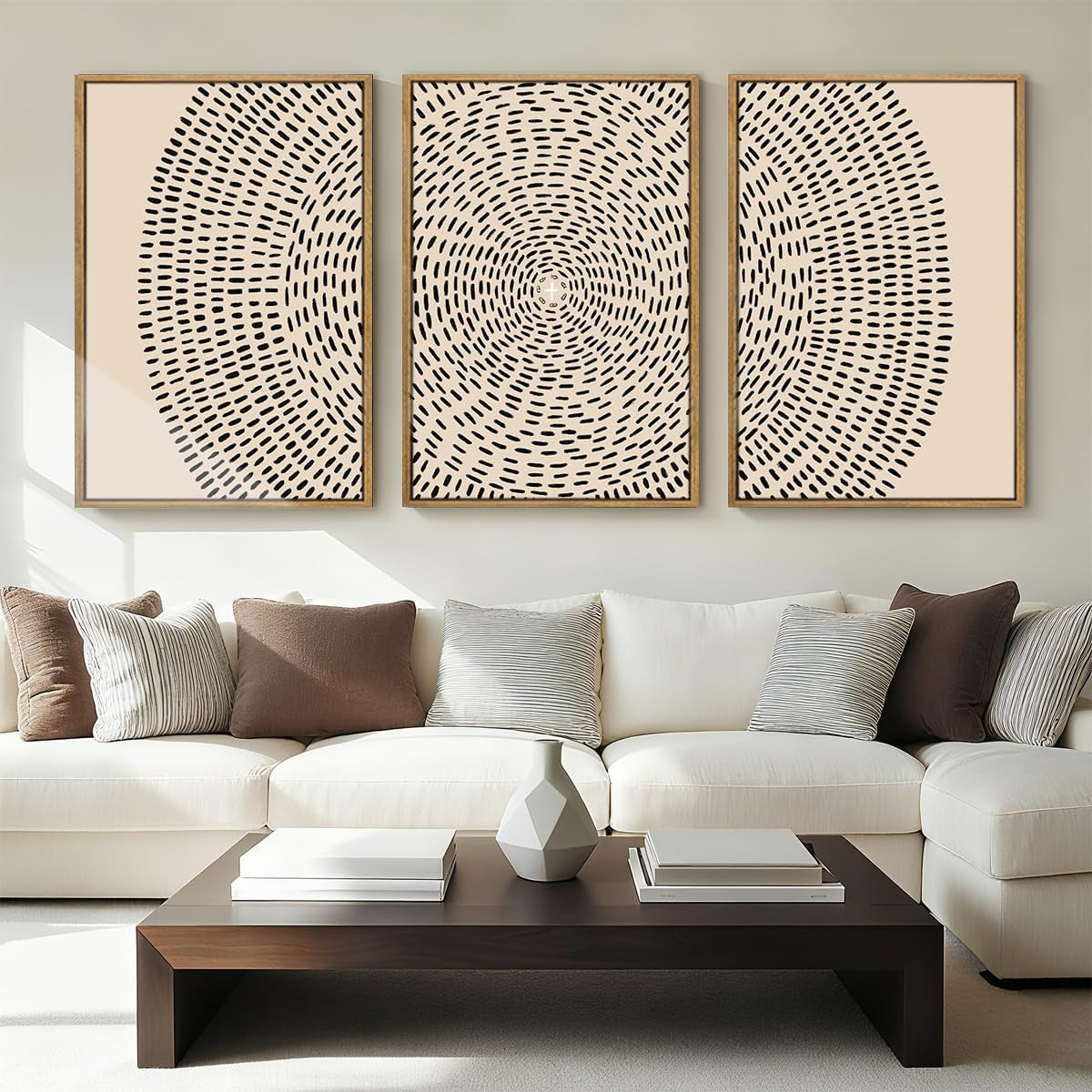 Triptych beige canvas prints with black dash circle motif in wood frames hung above a sofa and coffee table