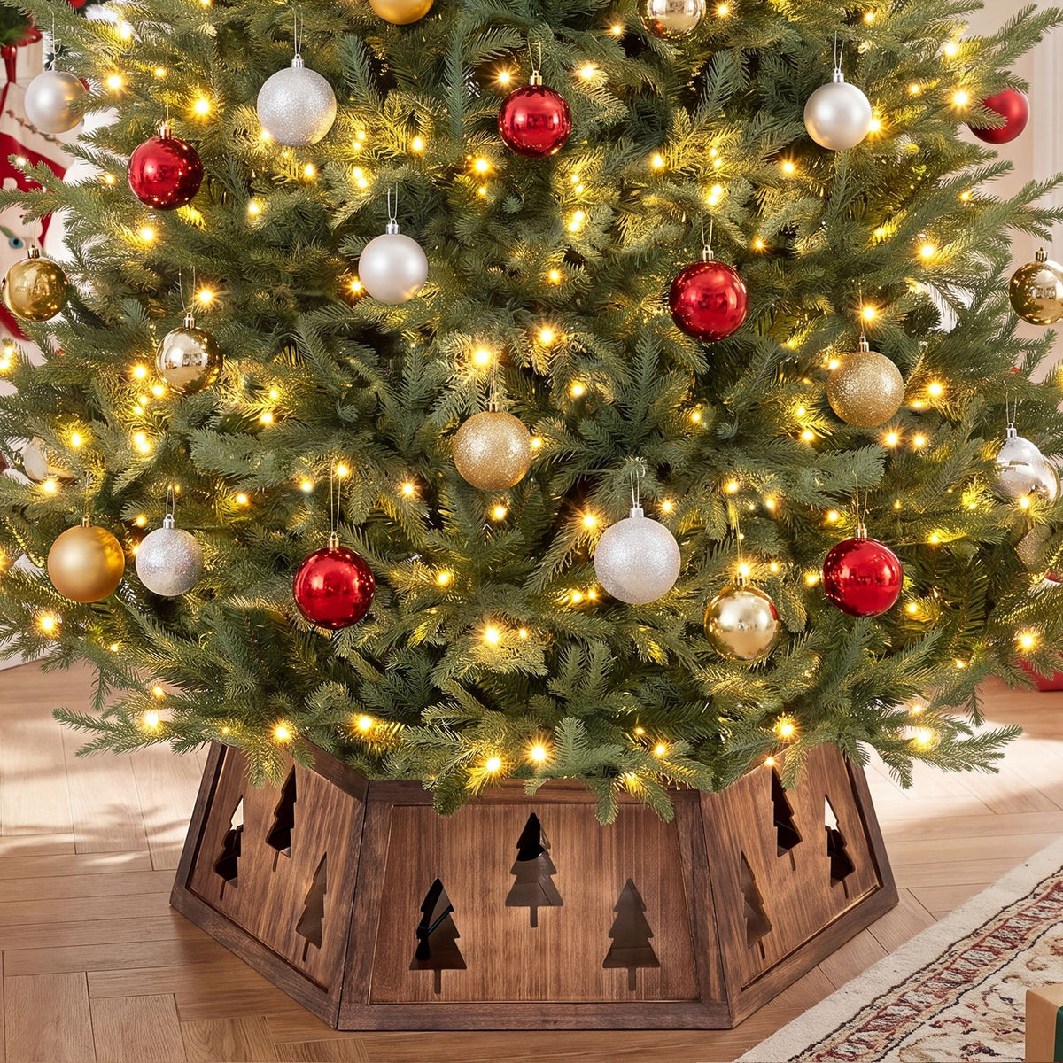 A lit Christmas tree stands inside a brown wooden collar with tree cutouts.