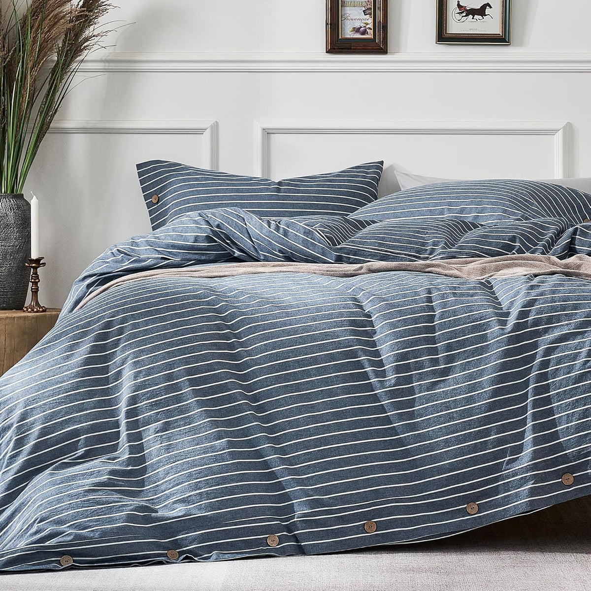 Bedroom close-up showing a blue striped duvet and matching pillows on a made bed with button details