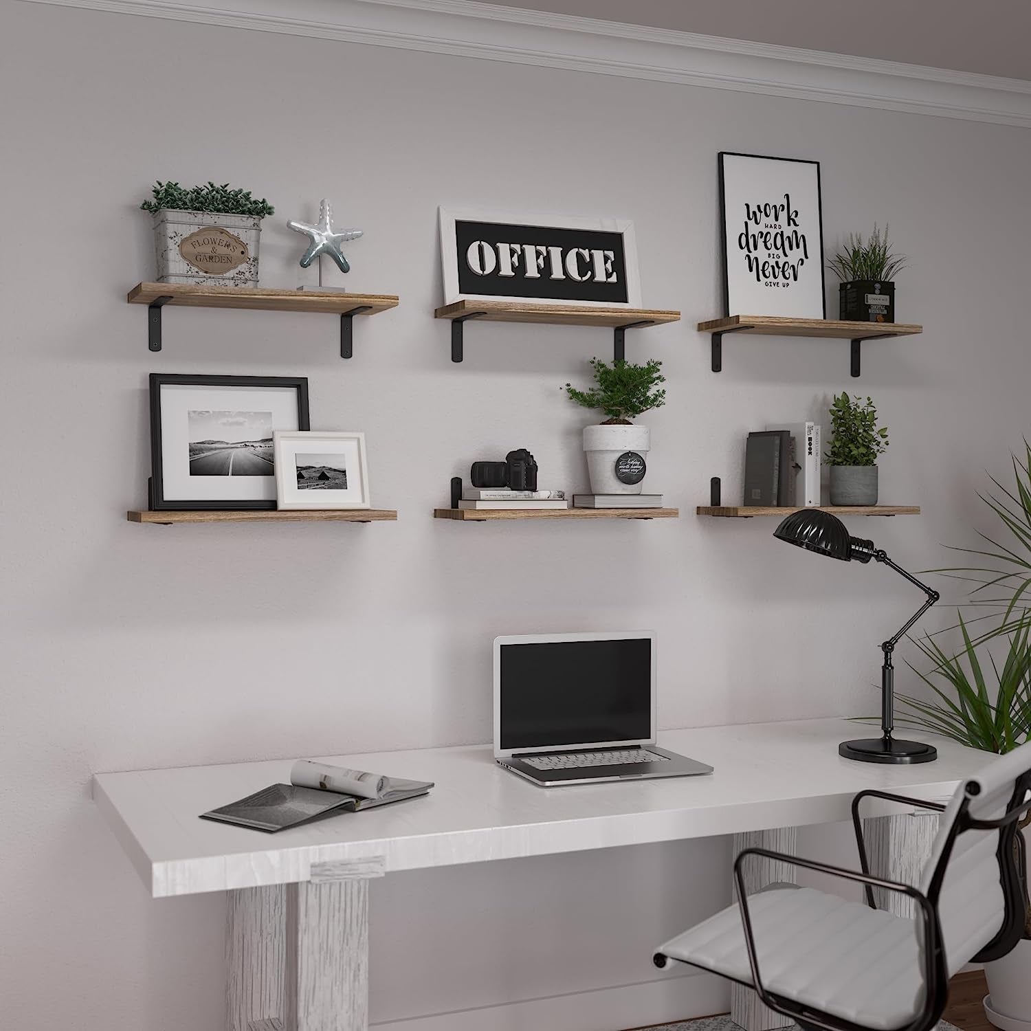 Six wood floating shelves in two rows above a white desk, each styled with frames, plants, and small decor.