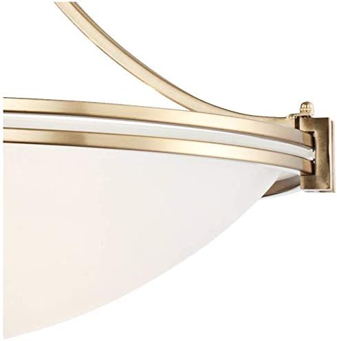Close-up of warm brass metal trim and the edge of the satin white glass bowl