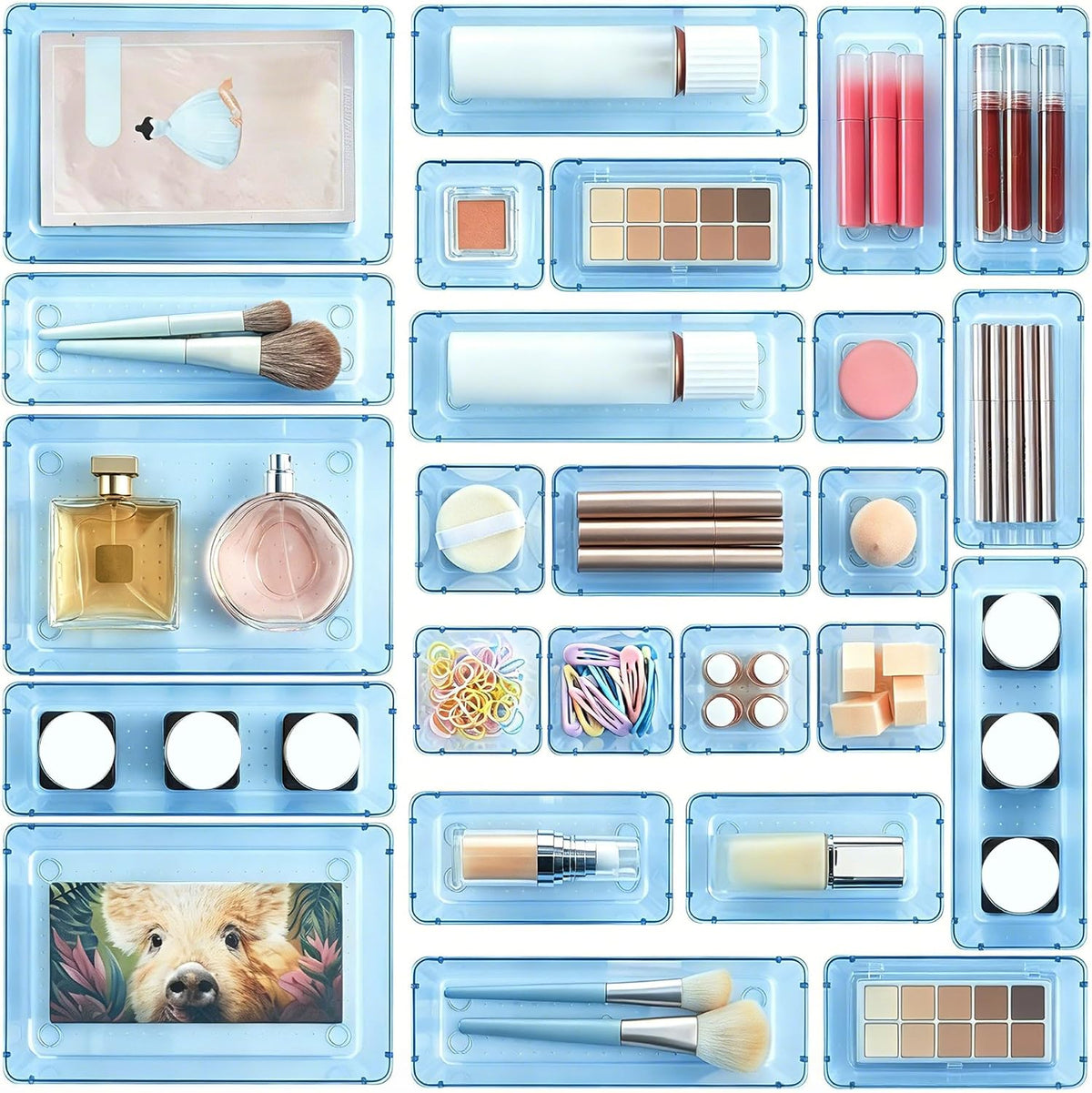 Multiple translucent blue trays arranged from above holding cosmetics, brushes, lipsticks and small accessories
