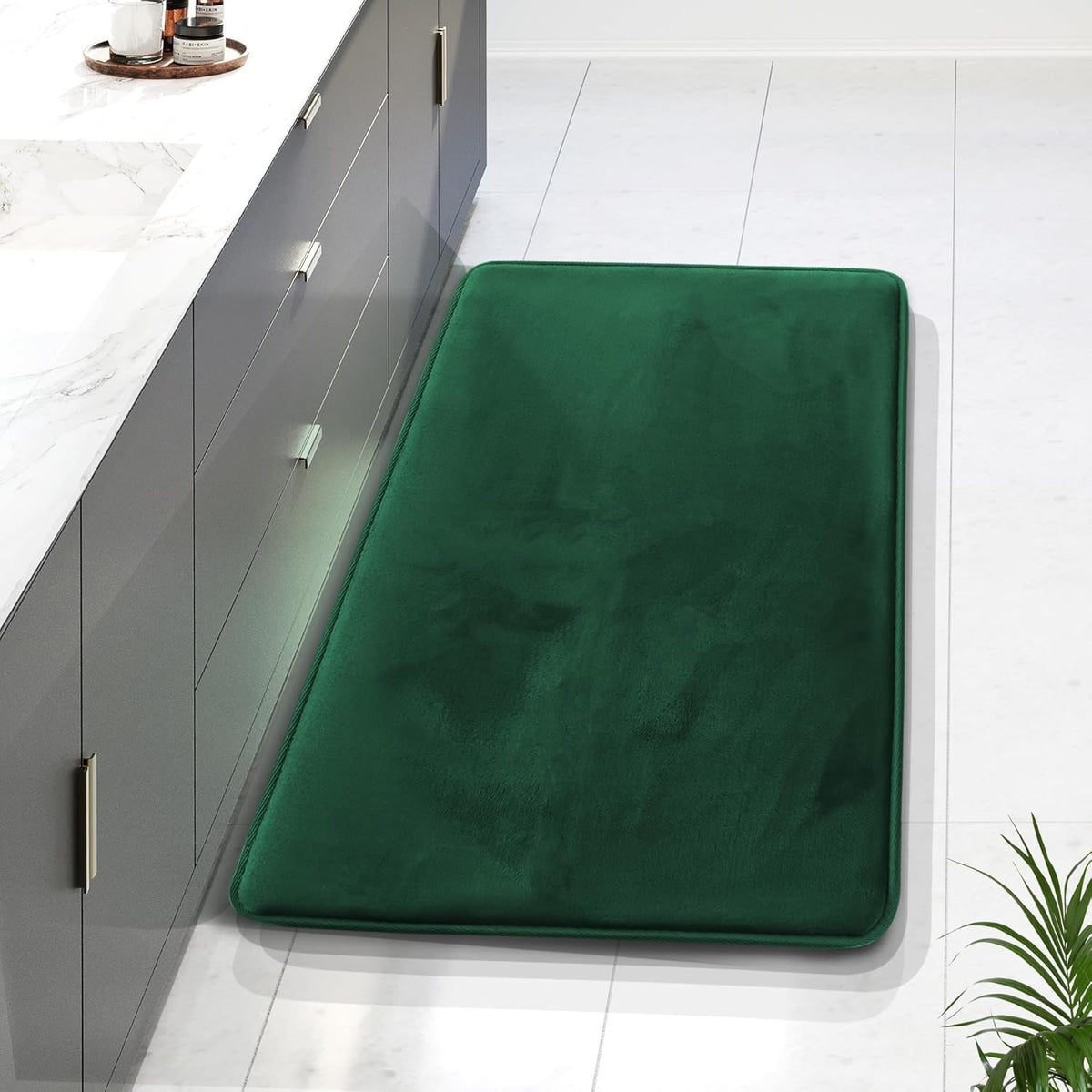 Close-up of a dark green rectangular runner mat placed alongside a bathroom vanity.