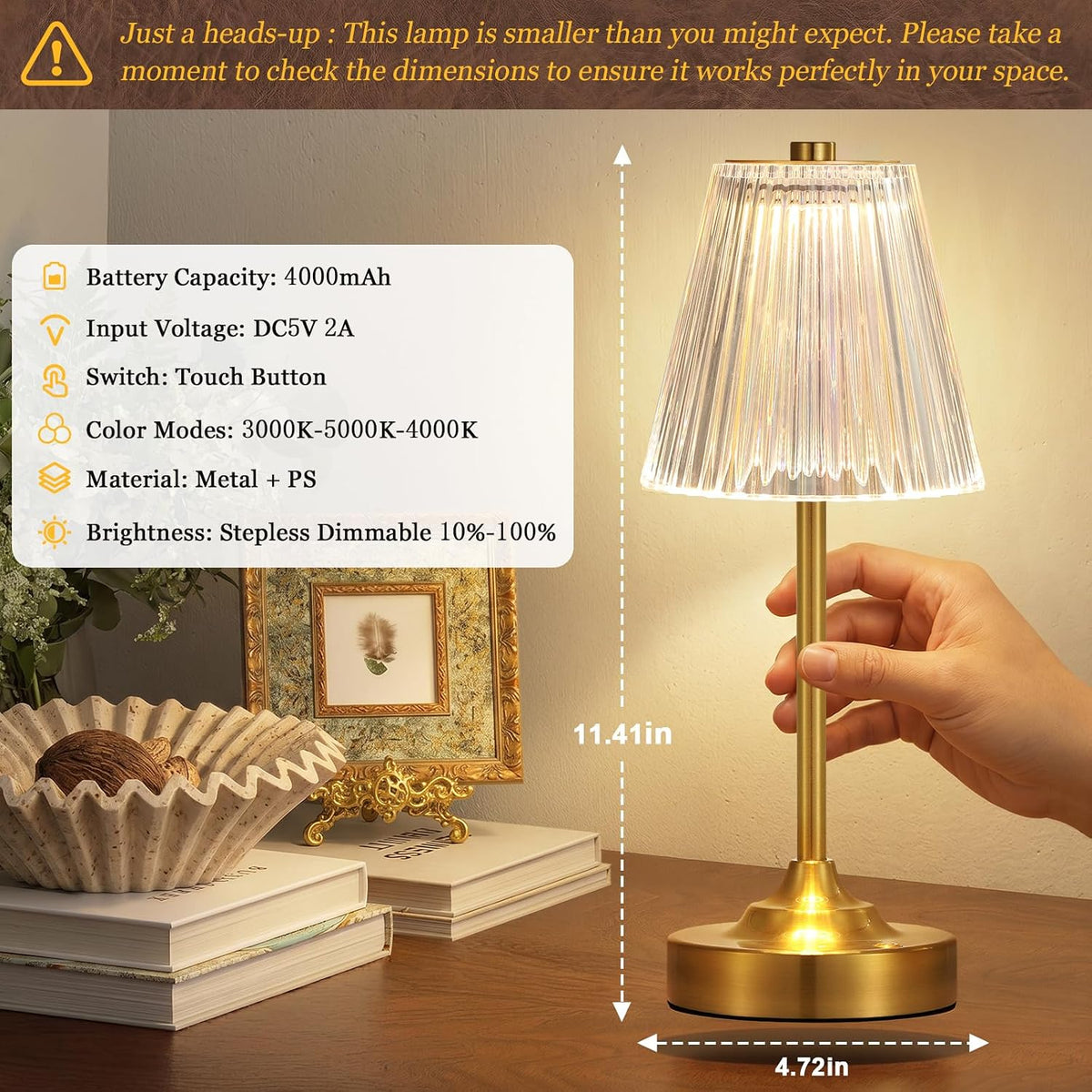 Close-up of gold table lamp lit on a desk with dimension overlays showing the lamp's height and base width