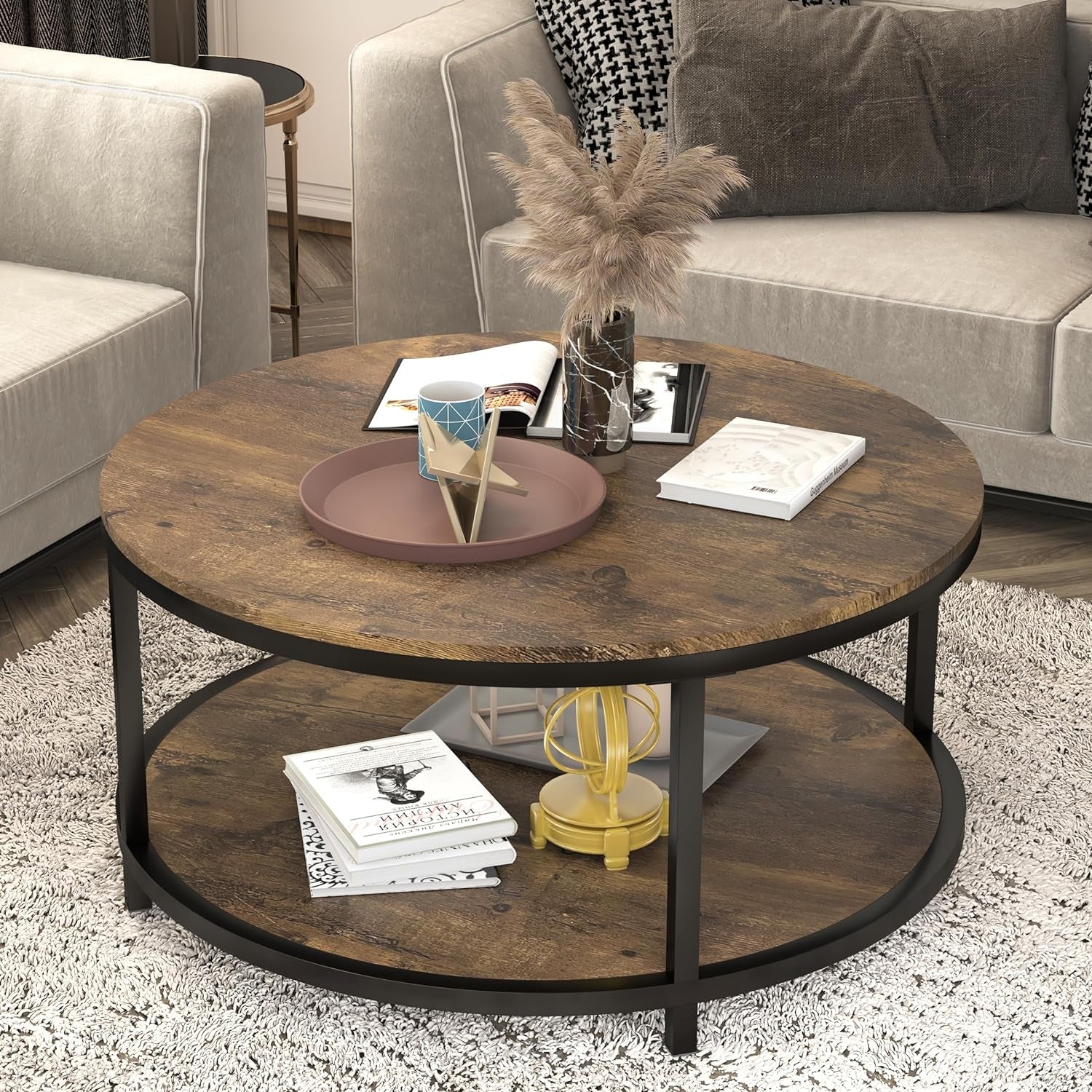 Light walnut round coffee table shown between sofas, decorated with tray, vase and stacked books