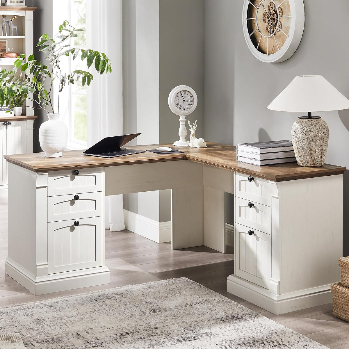 L-shaped corner desk with white base and warm wood top, styled with lamp, books, and a laptop.