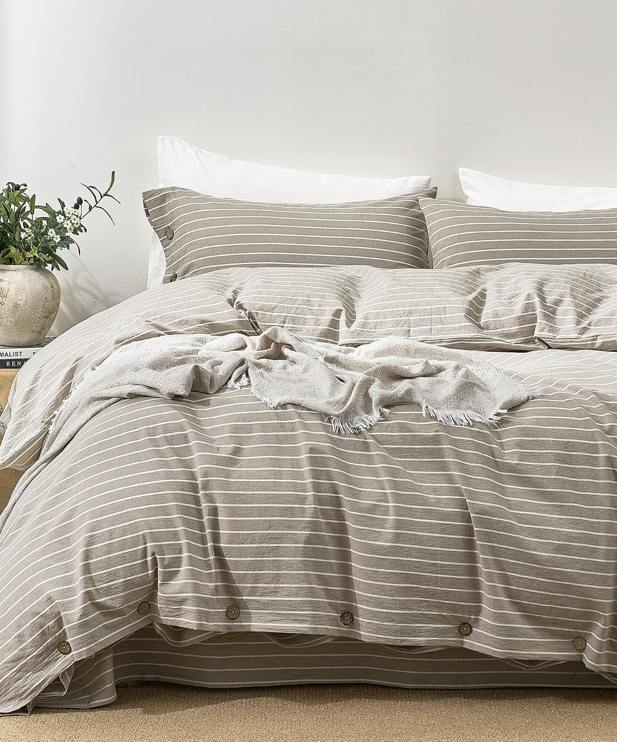 Head-on bed shot showing a taupe-and-white striped duvet and matching pillowcases with button closures.