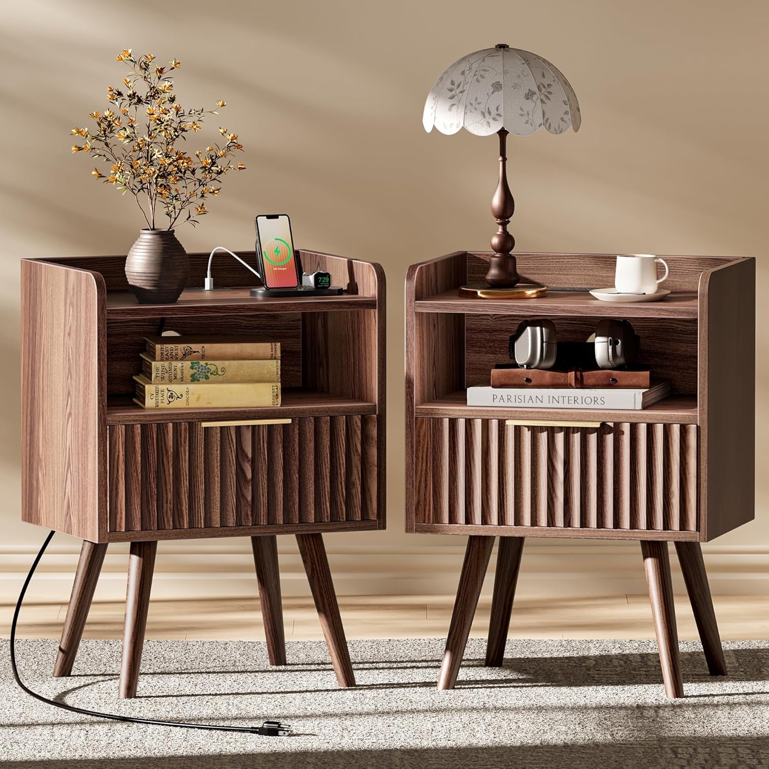 Pair of walnut fluted nightstands shown front view with devices on top and tapered solid wood legs